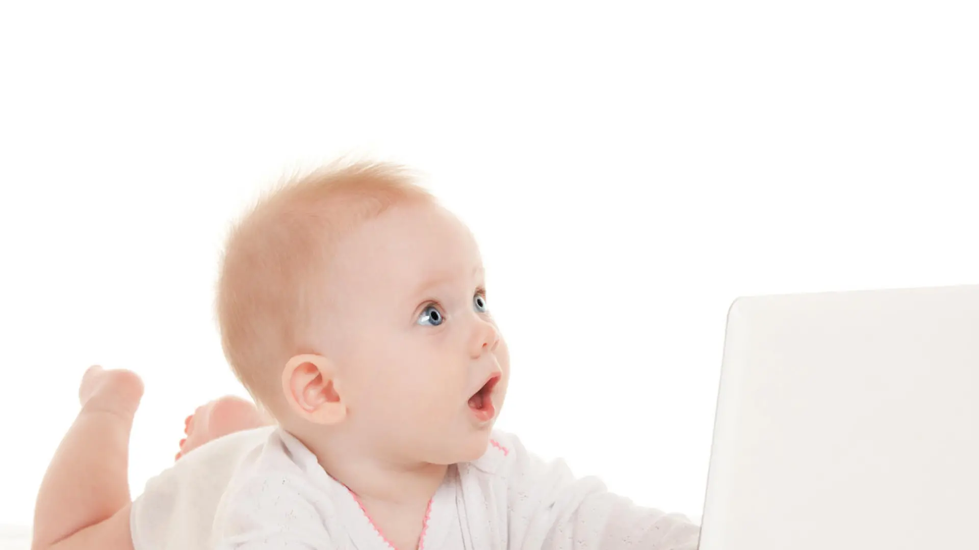 Cute baby with laptop on the white bed