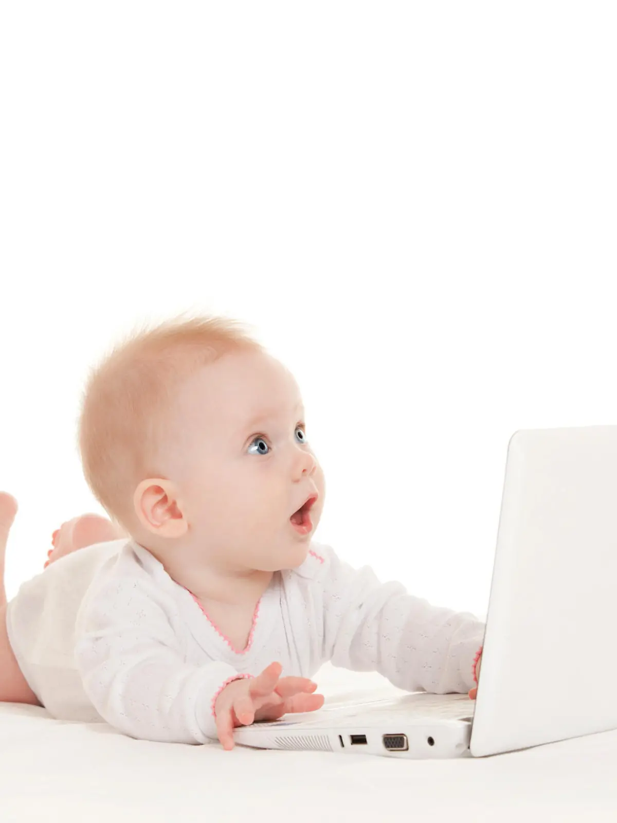 Cute baby with laptop on the white bed
