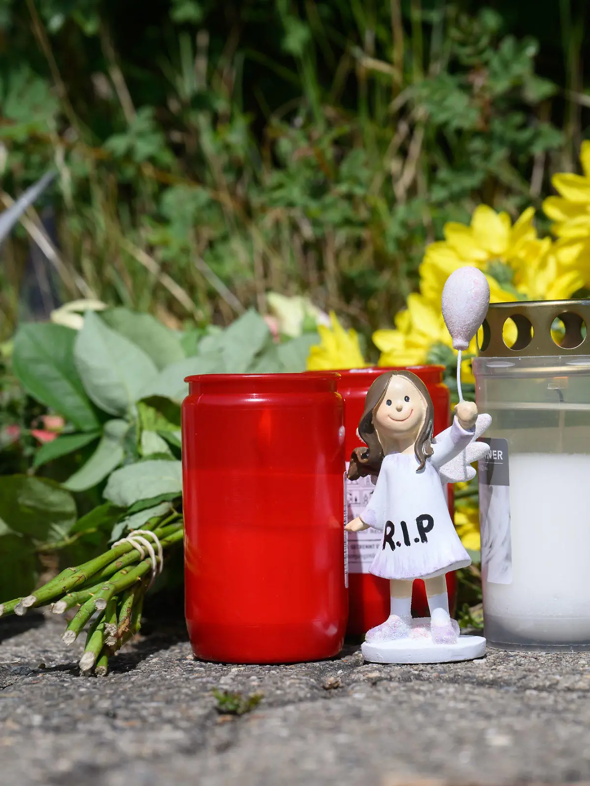 ARCHIV - 22.06.2022, Niedersachsen, Salzgitter: Kerzen, Blumen und Figuren zum Gedenken an eine getötete 15-Jährige liegen an einem Tatort an einer Grünfläche am Hans-Böckler-Ring in Salzgitter. Ein 13-Jähriger und ein 14-Jähriger sollen das Mädchen getötet haben - die Staatsanwaltschaft Braunschweig erhob Anklage gegen den Älteren der beiden. (zu dpa: «Tod eines 15-jährigen Mädchens - Mordprozess gegen Mitschüler beginnt») Foto: Julian Stratenschulte/dpa +++ dpa-Bildfunk +++