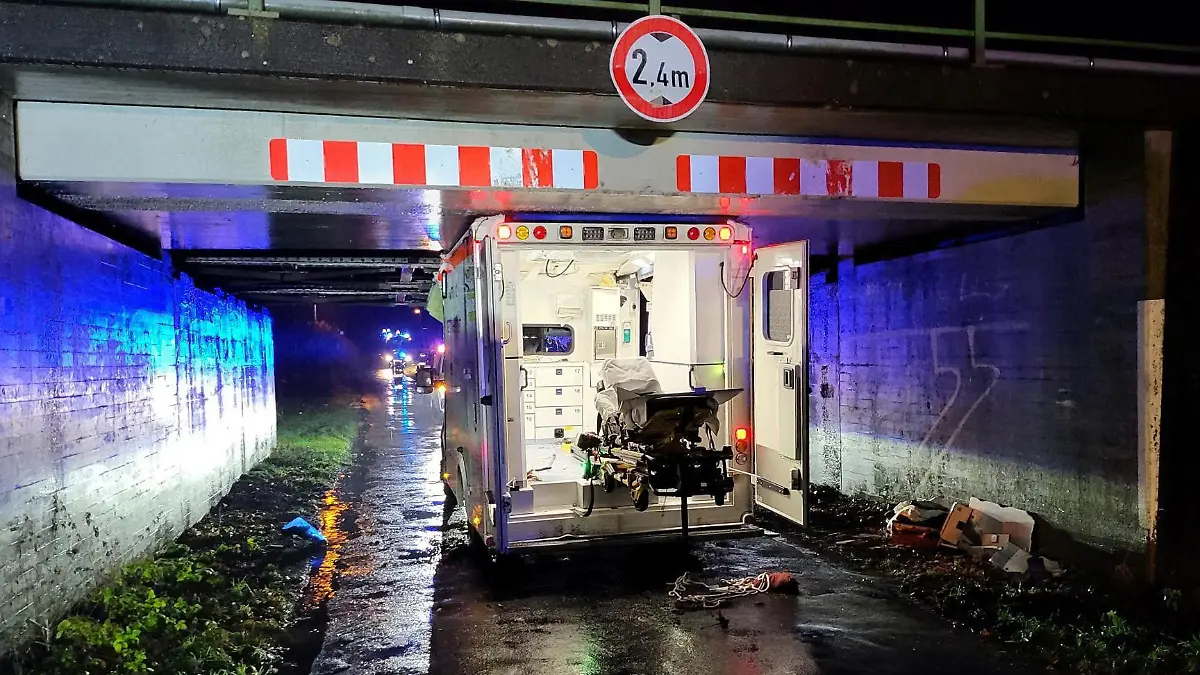 20.12.2022, Niedersachsen, Haren: Ein Rettungswagen steht eingeklemmt in einer Unterführung. Beim Unfall eines Rettungswagens in Haren (Landkreis Emsland) sind drei Menschen leicht verletzt worden. Der 26-jährige Fahrer habe auf der Einsatzfahrt am Dienstagabend die Höhe einer Brücke falsch eingeschätzt, sagte ein Polizeisprecher. Das entsprechende Verkehrszeichen habe er zu spät bemerkt. Foto: Torsten Albrecht/Nord-West-Media/dpa +++ dpa-Bildfunk +++
