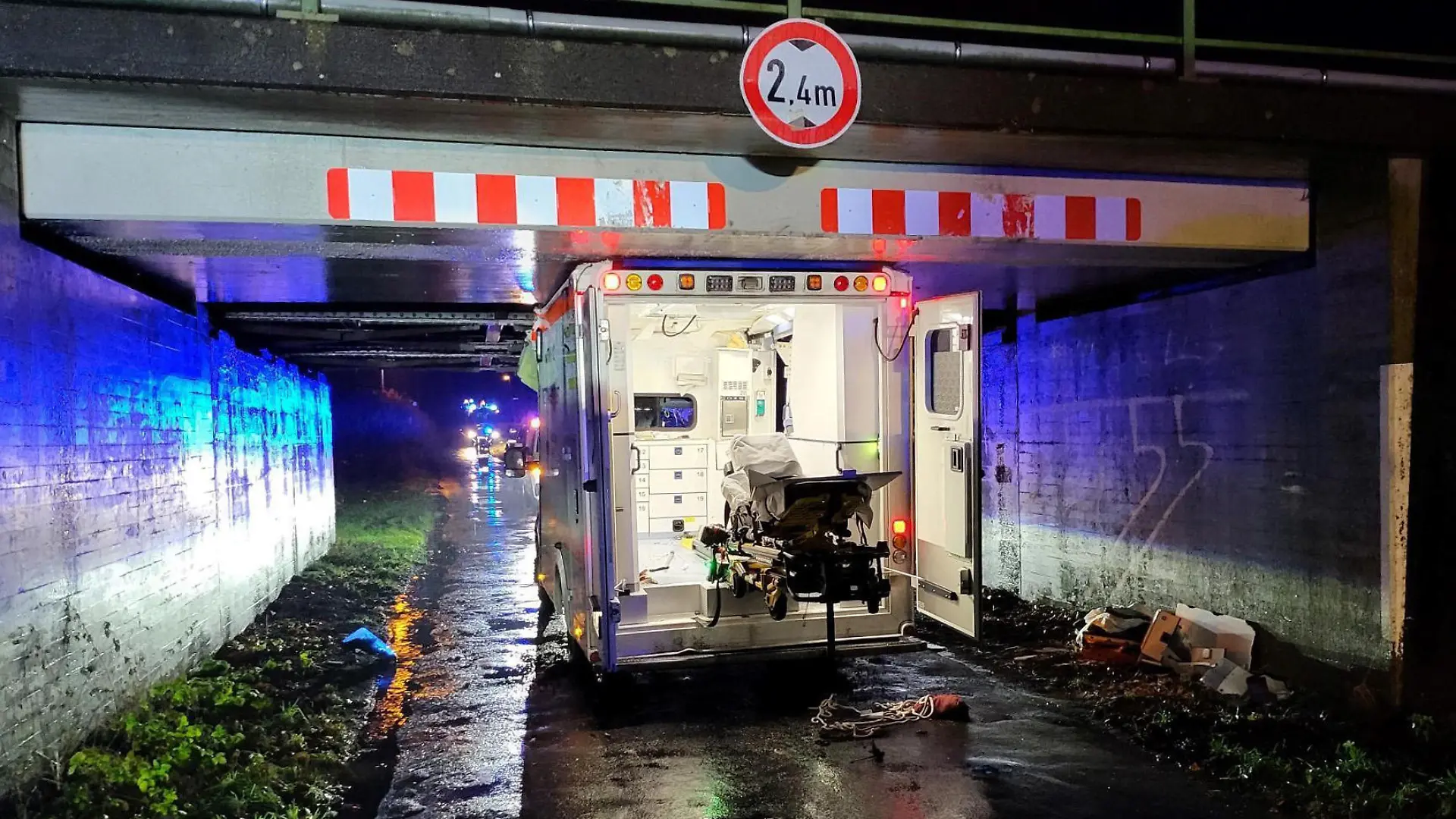 20.12.2022, Niedersachsen, Haren: Ein Rettungswagen steht eingeklemmt in einer Unterführung. Beim Unfall eines Rettungswagens in Haren (Landkreis Emsland) sind drei Menschen leicht verletzt worden. Der 26-jährige Fahrer habe auf der Einsatzfahrt am Dienstagabend die Höhe einer Brücke falsch eingeschätzt, sagte ein Polizeisprecher. Das entsprechende Verkehrszeichen habe er zu spät bemerkt. Foto: Torsten Albrecht/Nord-West-Media/dpa +++ dpa-Bildfunk +++