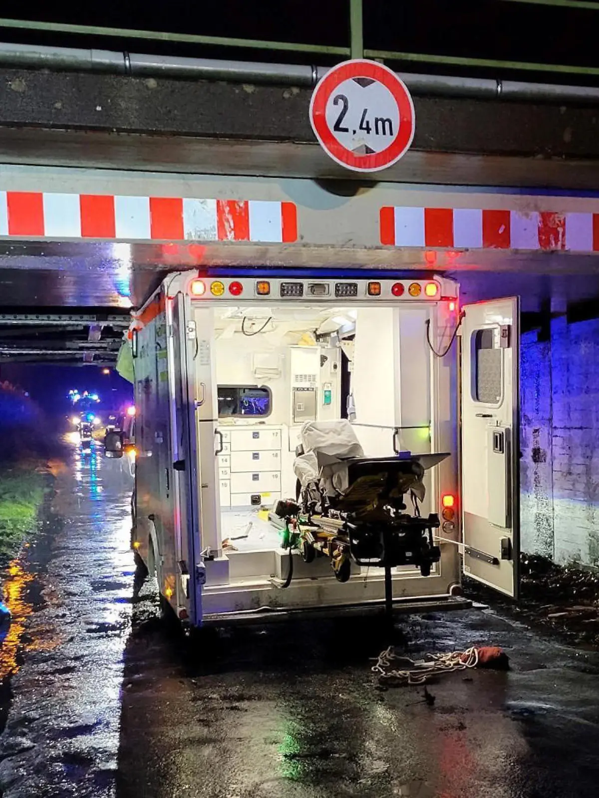 20.12.2022, Niedersachsen, Haren: Ein Rettungswagen steht eingeklemmt in einer Unterführung. Beim Unfall eines Rettungswagens in Haren (Landkreis Emsland) sind drei Menschen leicht verletzt worden. Der 26-jährige Fahrer habe auf der Einsatzfahrt am Dienstagabend die Höhe einer Brücke falsch eingeschätzt, sagte ein Polizeisprecher. Das entsprechende Verkehrszeichen habe er zu spät bemerkt. Foto: Torsten Albrecht/Nord-West-Media/dpa +++ dpa-Bildfunk +++