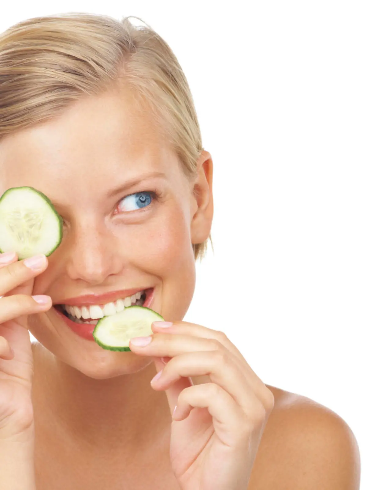 An attractive young woman biting a slice of cucumber on a white background