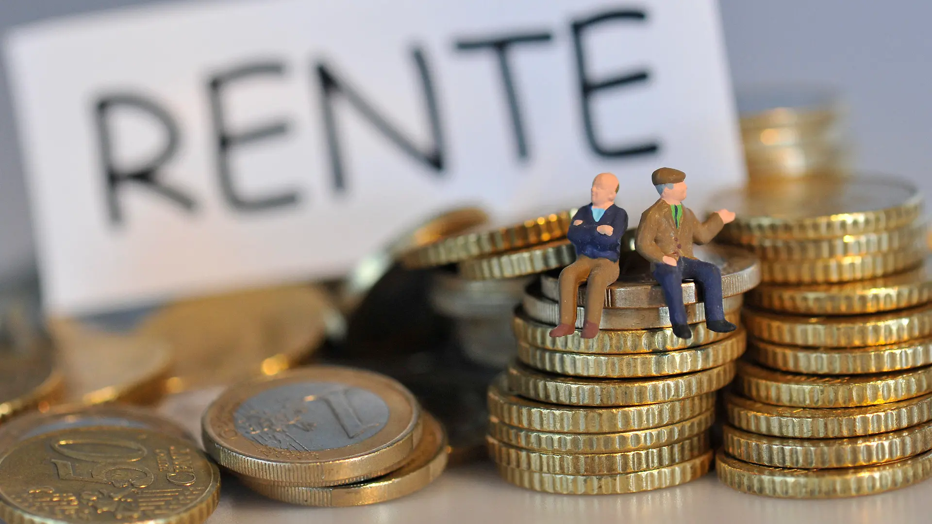 ARCHIV - ILLUSTRATION - Die Miniatur-Figuren zweier Rentner sitzen am 22.10.2010 auf einem Berg mit Euro-Münzen vor einem Schild mit der Aufschrift "Rente" (Archivbild vom 22.01.2010). Die Renten steigen am 1. Juli deutlich - im Osten um 2,26 Prozent, im Westen um 2,18 Prozent. Foto: Andreas Gebert dpa (zu dpa 40947 am 12.03.2012) +++(c) dpa - Bildfunk+++