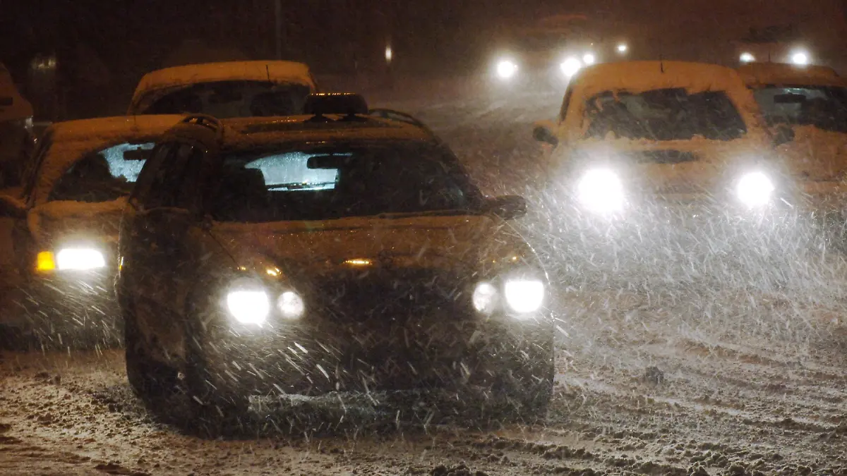 Autofahrer bewegen sich in der Nacht zum Freitag (25.11.2005) in der Innenstadt von Frankfurt am Main auf einer verschneiten Straße. Tief "Thorsten" sorgt in den Niederungen für eine Schneedecke von bis zu fünf Zentimetern. Autofahrer müssen sich deshalb im Berufsverkehr auf die ersten Rutschpartien auf Schnee und Eis einstellen. Foto: Arne Dedert dpa/lhe +++(c) dpa - Bildfunk+++