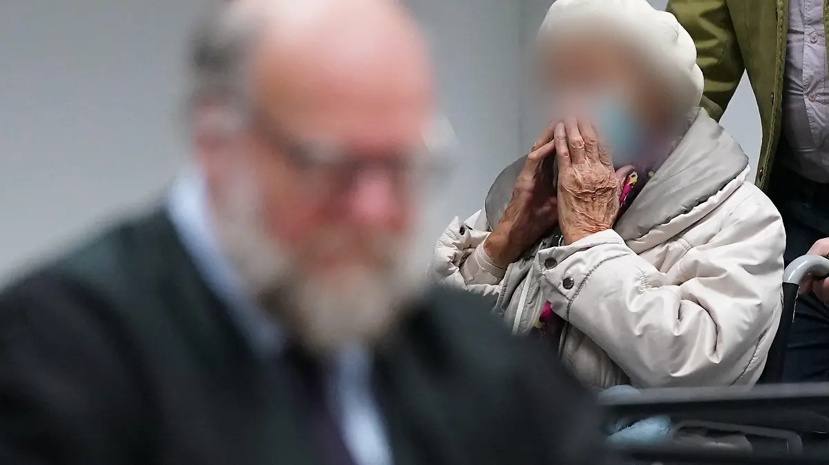 06.12.2022, Schleswig-Holstein, Itzehoe: Die Angeklagte Irmgard F. (r) wird zu Beginn des Prozesstages in den Sitzungssaal gebracht. Links im Bild sitzt ihr Anwalt Wolf Molkentin. Der Prozess gegen die ehemalige KZ-Sekretärin vor dem Landgericht Itzehoe wird mit dem Plädoyer der Verteidigung fortgesetzt. Der 97-Jährigen wird Beihilfe zum Mord in über 11.000 Fällen zur Last gelegt. Foto: Marcus Brandt/dpa POOL/dpa - ACHTUNG: Die Angeklagte wurde aus rechtlichen Gründen gepixelt +++ dpa-Bildfunk +++