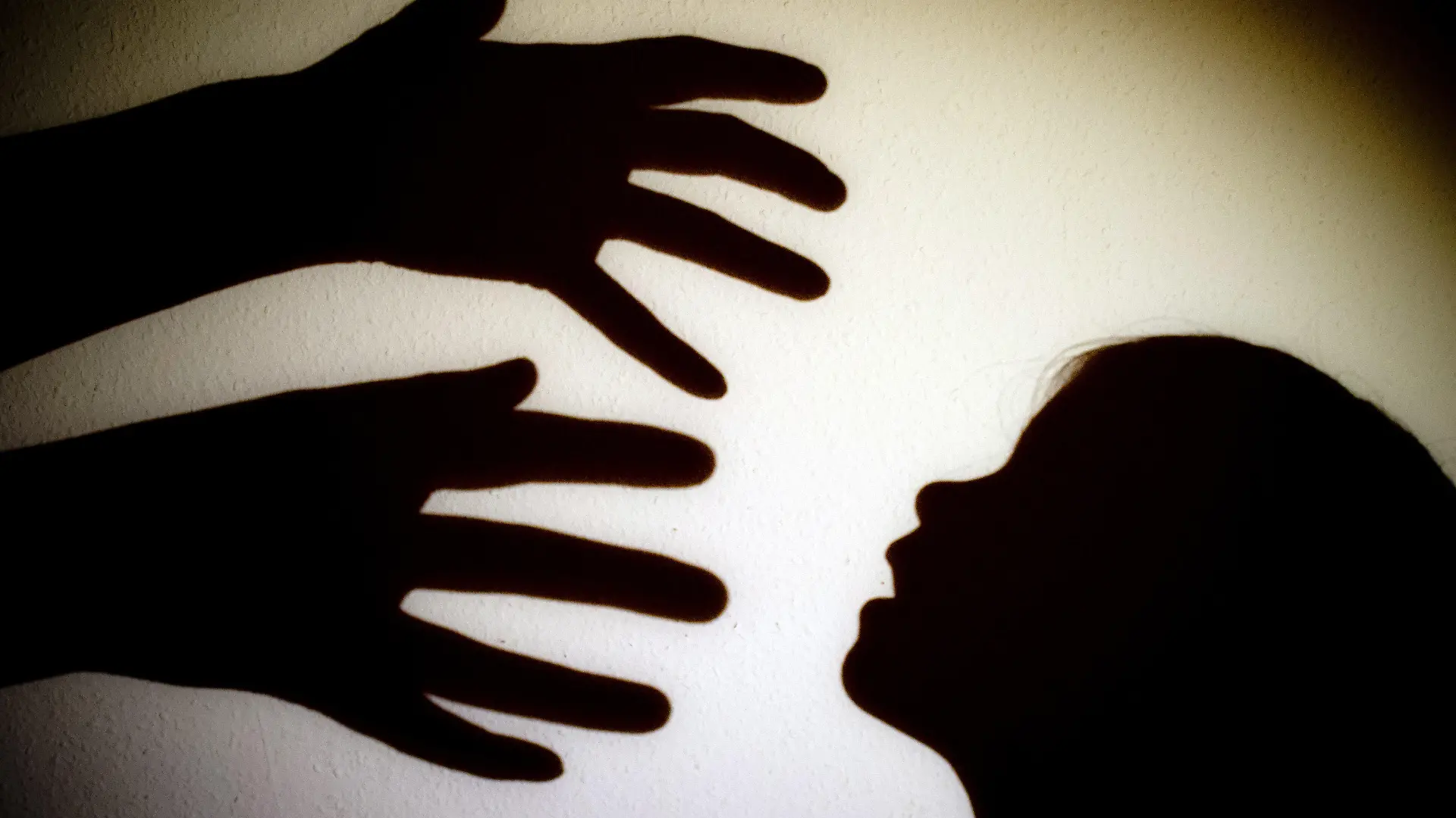 ARCHIV - 12.01.2014, Brandenburg, Frankfurt (Oder): ILLUSTRATION - Schatten von Händen einer erwachsenen Person und dem Kopf eines Kindes an einer Wand eines Zimmers. (zu dpa «Staatsanwaltschaften registrieren 1344 Fälle von Kindesmissbrauch» vom 6.2.2021) Foto: Patrick Pleul/zb/dpa +++ dpa-Bildfunk +++