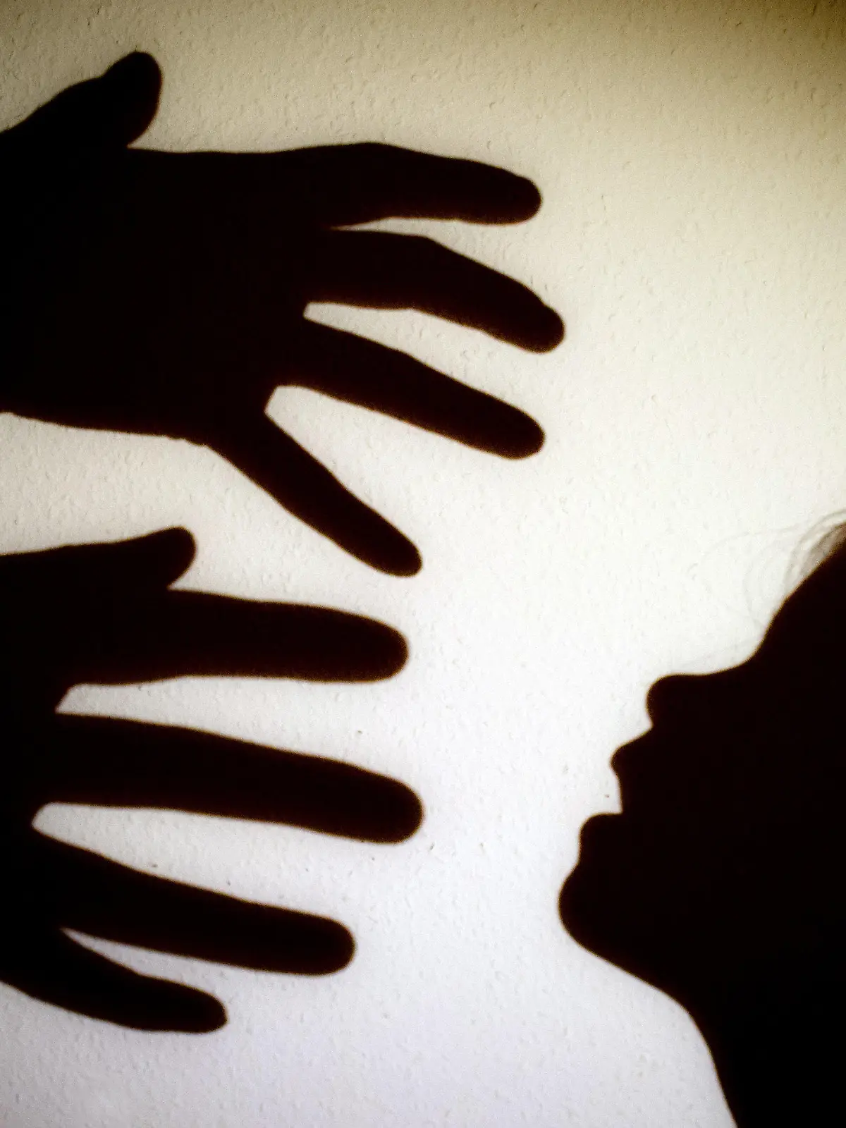 ARCHIV - 12.01.2014, Brandenburg, Frankfurt (Oder): ILLUSTRATION - Schatten von Händen einer erwachsenen Person und dem Kopf eines Kindes an einer Wand eines Zimmers. (zu dpa «Staatsanwaltschaften registrieren 1344 Fälle von Kindesmissbrauch» vom 6.2.2021) Foto: Patrick Pleul/zb/dpa +++ dpa-Bildfunk +++