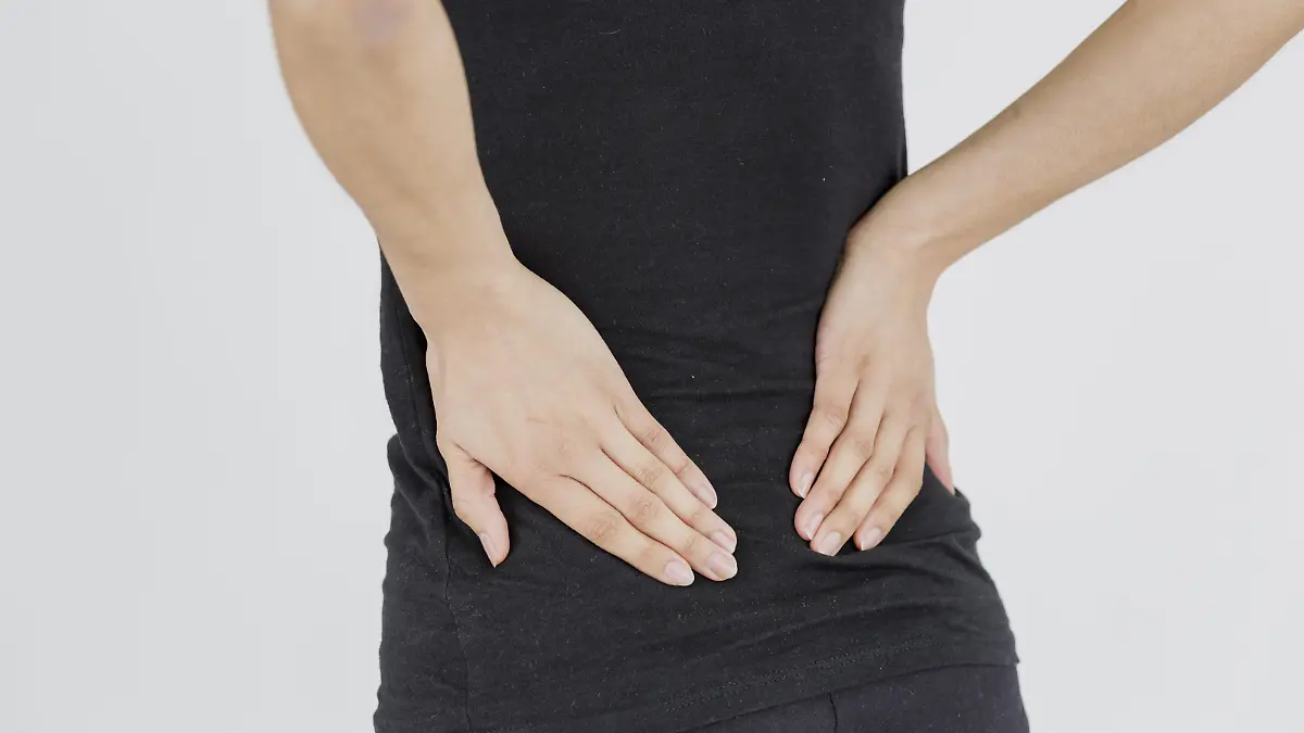 ILLUSTRATION - Eine junge Frau hat am 16.03.2015 in einem Studio in Berlin Rueckenschmerzen. Foto: Monique Wuestenhagen | Verwendung weltweit