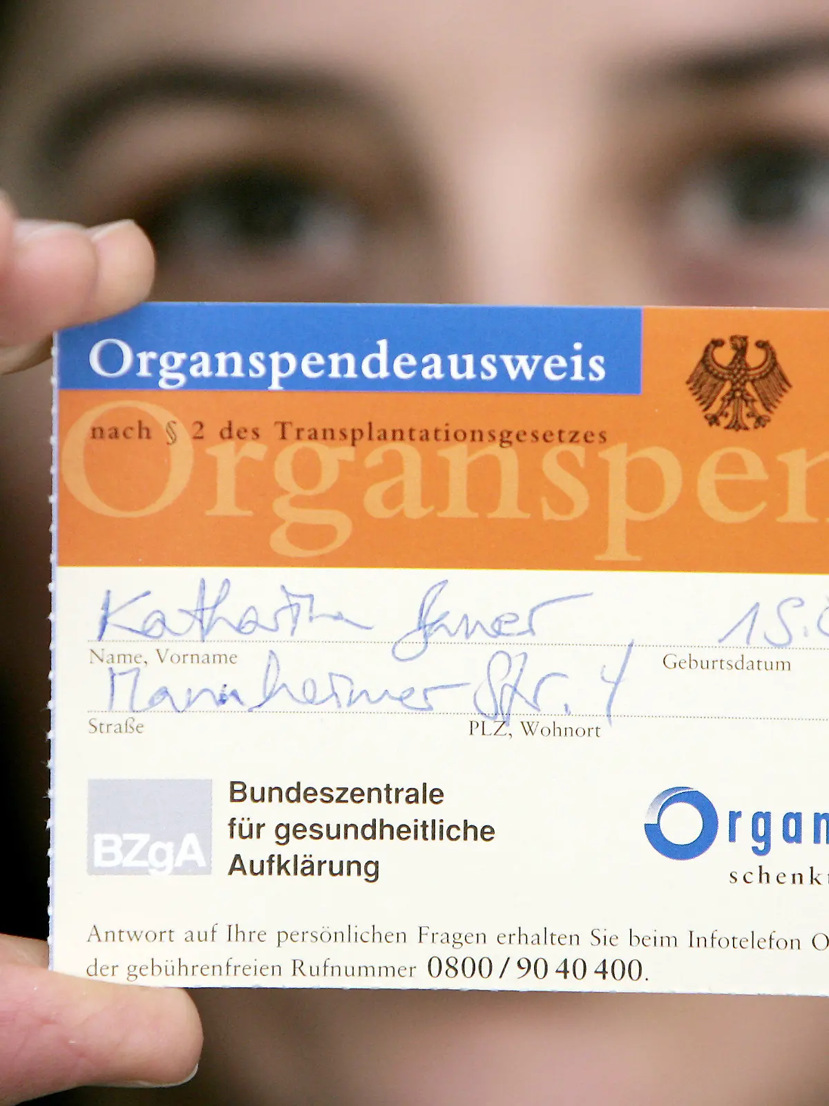ARCHIV - Eine junge Frau zeigt in Frankfurt/Main einen Organspenderausweis (Archivfoto vom 18.02.2005). Der Bundestag entscheidet heute (25.05.2012) über die Organspende-Reform. Derzeit warten rund 12 000 Menschen auf ein Organ. Dennoch hat nur eine Minderheit der Bundesbürger einen Organspendeausweis ausgefüllt. Künftig soll die Entscheidungslösung gelten: Alle Bürger sollen von ihren Krankenkassen schriftlich gefragt werden, ob sie nach dem Hirntod zur Spende bereit sind.  Foto: Frank May dpa  +++(c) dpa - Bildfunk+++