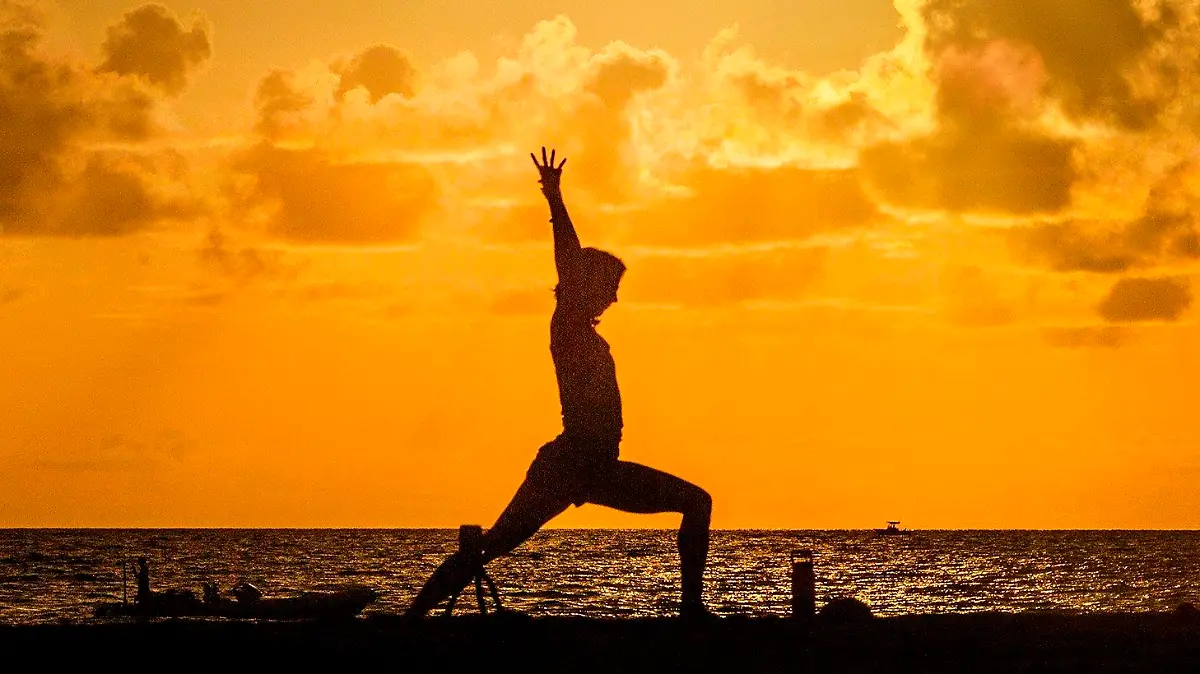 30.07.2020, USA, Palm Beach: Eine Frau macht am Midtown Beach bei Sonnenaufgang Yoga. Foto: Lannis Waters/Palm Beach Post via ZUMA Wire/dpa +++ dpa-Bildfunk +++