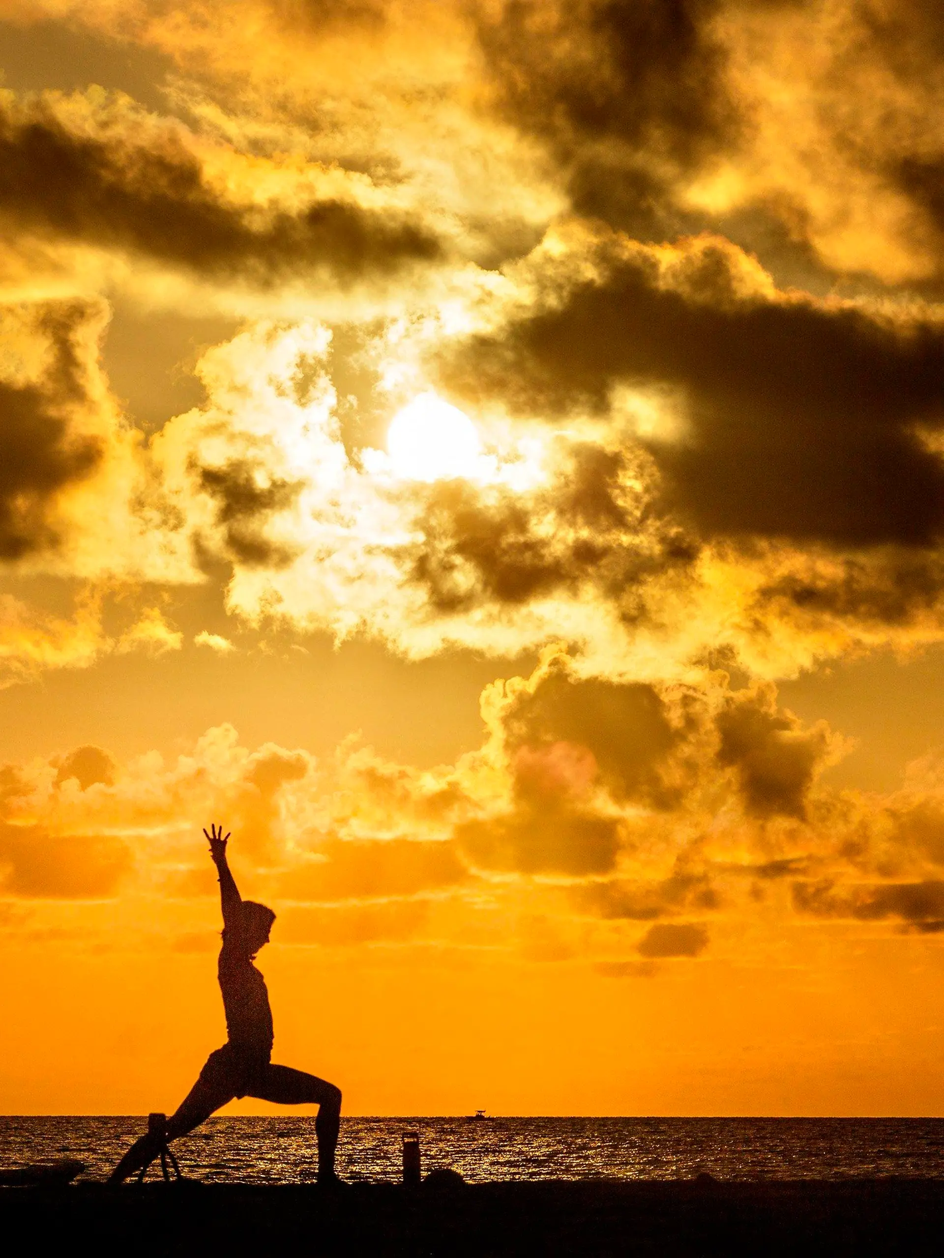 30.07.2020, USA, Palm Beach: Eine Frau macht am Midtown Beach bei Sonnenaufgang Yoga. Foto: Lannis Waters/Palm Beach Post via ZUMA Wire/dpa +++ dpa-Bildfunk +++