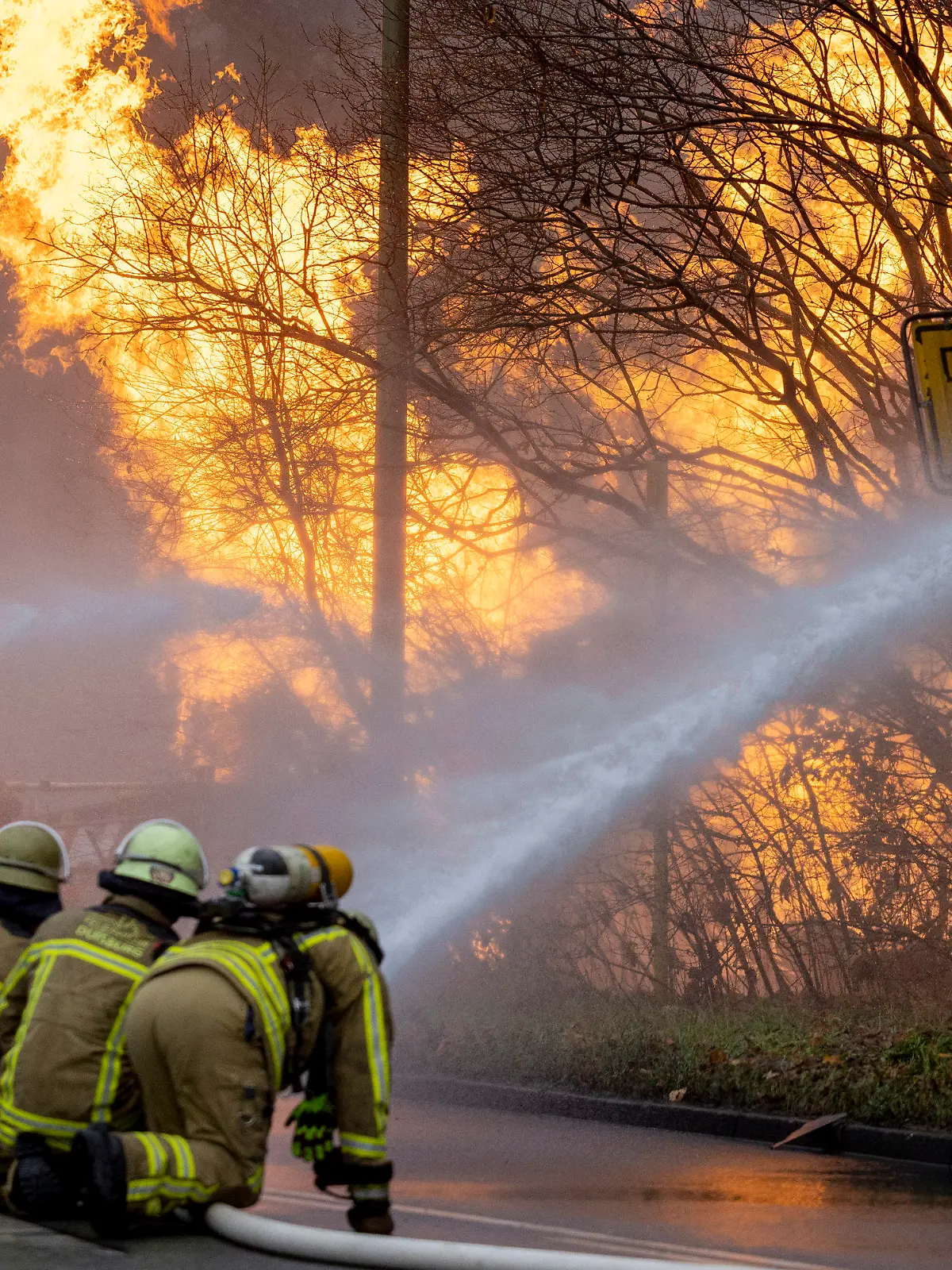 20.12.2022, Nordrhein-Westfalen, Duisburg: Feuerwehrleute arbeiten daran, ein brennendes Gasleck zu löschen. Die Gasleitung war bei Bauarbeiten beschädigt worden. Foto: Christoph Reichwein/dpa +++ dpa-Bildfunk +++