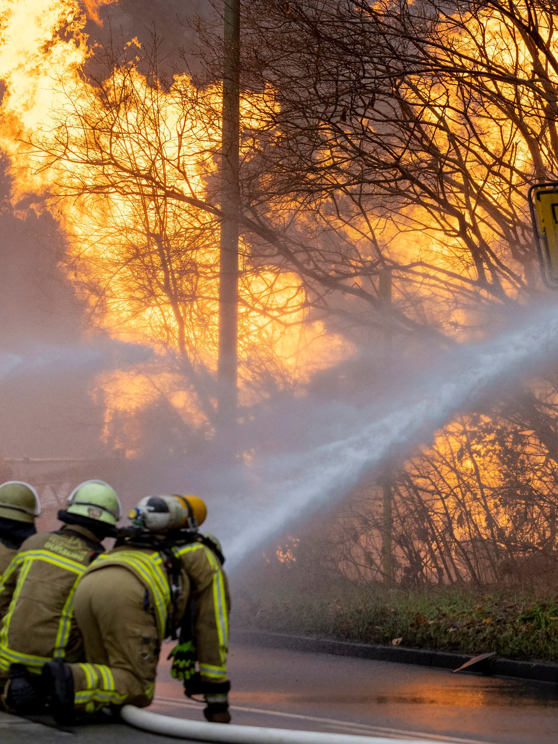 20.12.2022, Nordrhein-Westfalen, Duisburg: Feuerwehrleute arbeiten daran, ein brennendes Gasleck zu löschen. Die Gasleitung war bei Bauarbeiten beschädigt worden. Foto: Christoph Reichwein/dpa +++ dpa-Bildfunk +++