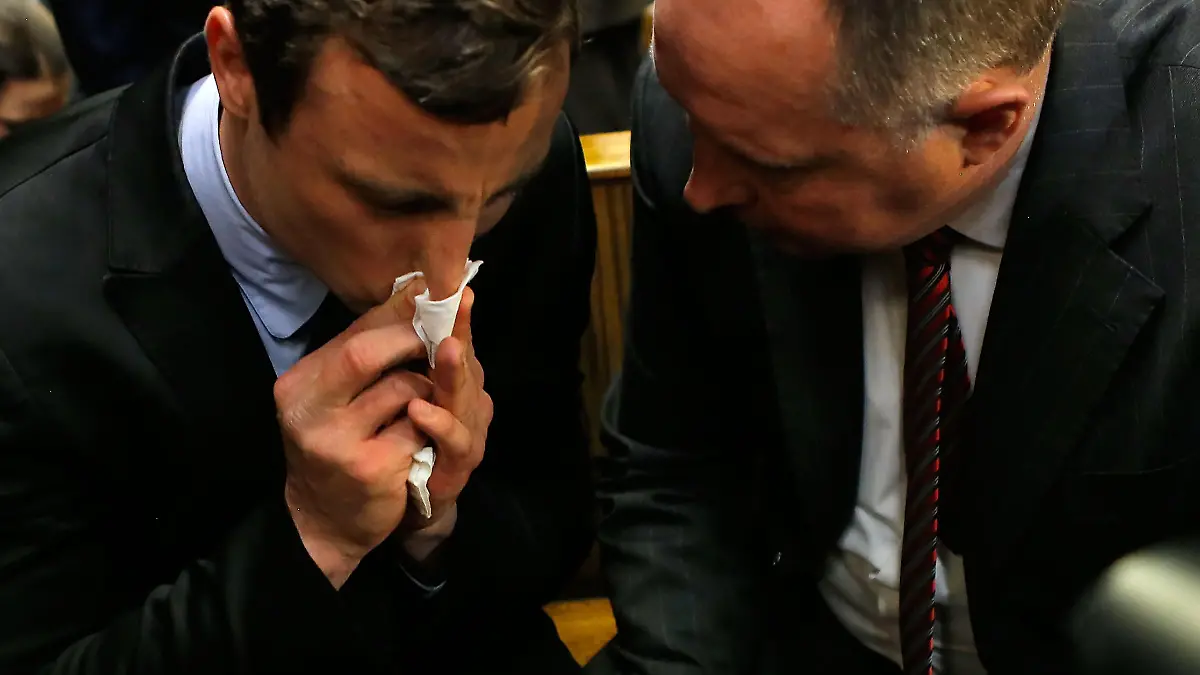 PRETORIA, SOUTH AFRICA - AUGUST 19: South African athlete Oscar Pistorius (L) speaks with his lawyer Kenny Oldwage in Pretoria Magistrates Court prior to an indictment hearing on August 19, 2013 in Pretoria, South Africa. Pistorius, 26 is accused of murdering his girlfriend Reeva Steenkamp which Pistorius denies claiming he mistook Steenkamp for an intruder. The indictment was served and the trial date of March 3, 2014 has now been set. (Photo by Jemal Countess/Getty Images)