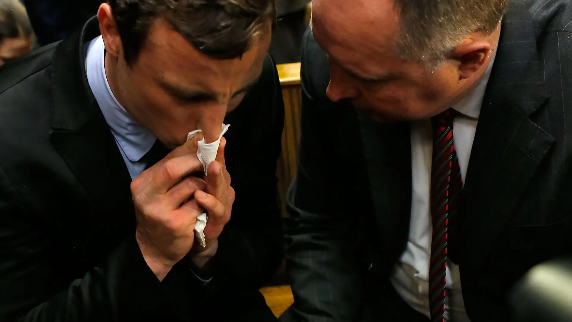 PRETORIA, SOUTH AFRICA - AUGUST 19: South African athlete Oscar Pistorius (L) speaks with his lawyer Kenny Oldwage in Pretoria Magistrates Court prior to an indictment hearing on August 19, 2013 in Pretoria, South Africa. Pistorius, 26 is accused of murdering his girlfriend Reeva Steenkamp which Pistorius denies claiming he mistook Steenkamp for an intruder. The indictment was served and the trial date of March 3, 2014 has now been set. (Photo by Jemal Countess/Getty Images)