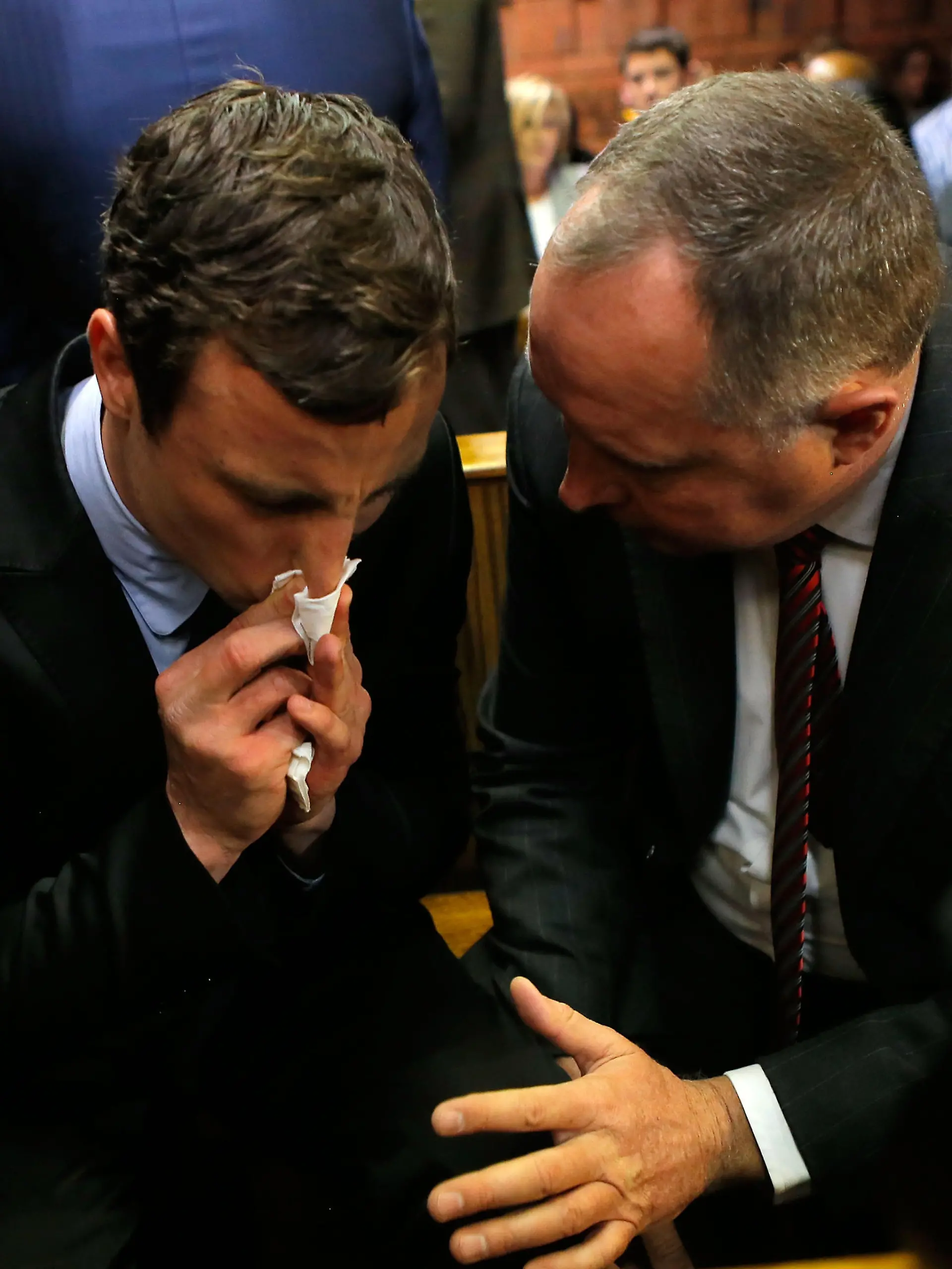 PRETORIA, SOUTH AFRICA - AUGUST 19: South African athlete Oscar Pistorius (L) speaks with his lawyer Kenny Oldwage in Pretoria Magistrates Court prior to an indictment hearing on August 19, 2013 in Pretoria, South Africa. Pistorius, 26 is accused of murdering his girlfriend Reeva Steenkamp which Pistorius denies claiming he mistook Steenkamp for an intruder. The indictment was served and the trial date of March 3, 2014 has now been set. (Photo by Jemal Countess/Getty Images)