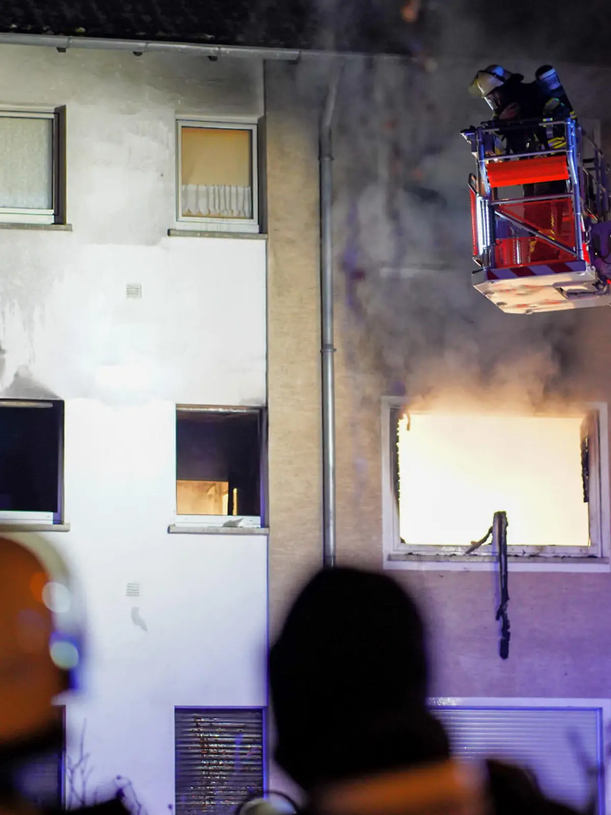 19.12.2022, Hessen, Wiesbaden: Feuerwehrleute mit Atemschutz löschen von einer Drehleiter aus den Brand in einem Haus. Bei einem Wohnungsbrand in Wiesbaden-Dotzheim ist ein Mann ums Leben gekommen. Der Bewohner konnte in der Nacht zu Montag zwar aus seiner brennenden Wohnung befreit werden, wie die Feuerwehr am frühen Montagmorgen mitteilte. Er starb jedoch trotz Reanimationsmaßnahmen noch vor Ort. Foto: -/5vision.media/dpa +++ dpa-Bildfunk +++