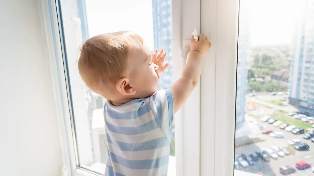 Kleinkind versucht Fenster zu öffnen