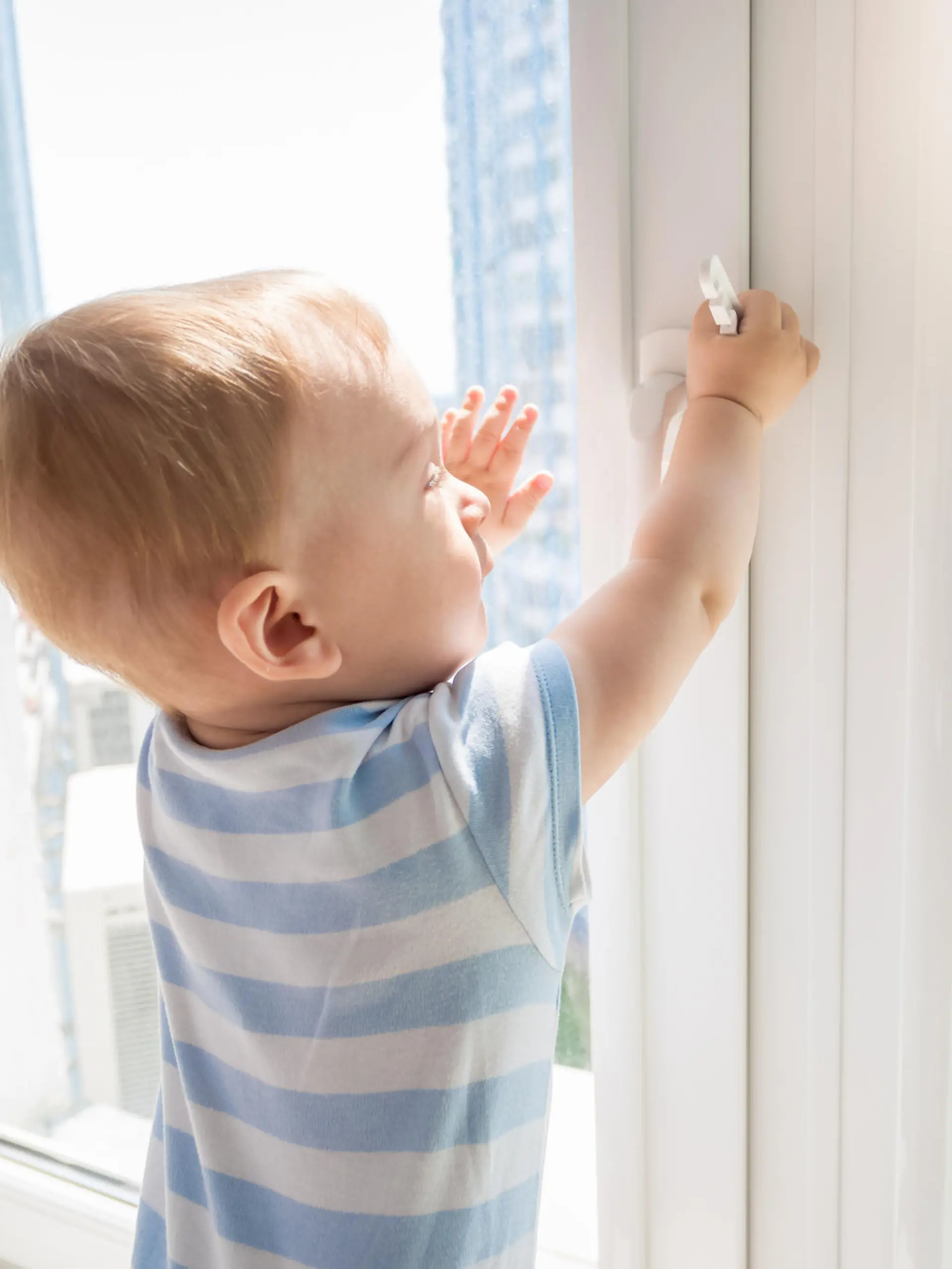 Kleinkind versucht Fenster zu öffnen