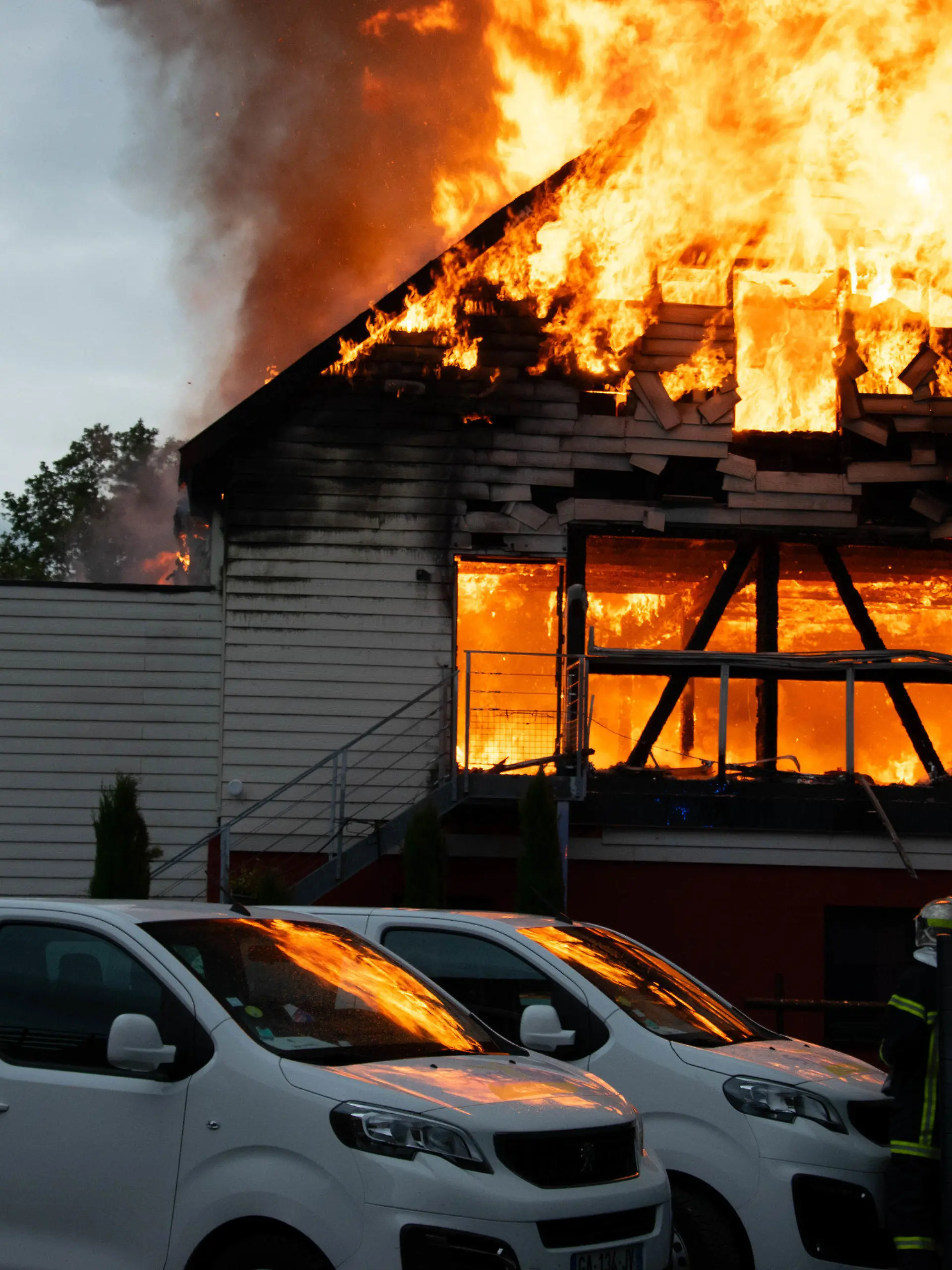09.08.2023, Frankreich, Wintzenheim: Feuerwehrleute löschen einen Brand in einer Ferienunterkunft. Elf Menschen wurden nach dem Feuer vermisst. Frankreichs Innenminister Gerald Darmanin zufolge beherbergt die Stätte behinderte Menschen. Die Präfektur schrieb, dass sich eine Erwachsenengruppe aus Nancy für die Ferien in der Unterkunft aufhielt. Foto: Patrick Kerber/dpa +++ dpa-Bildfunk +++
