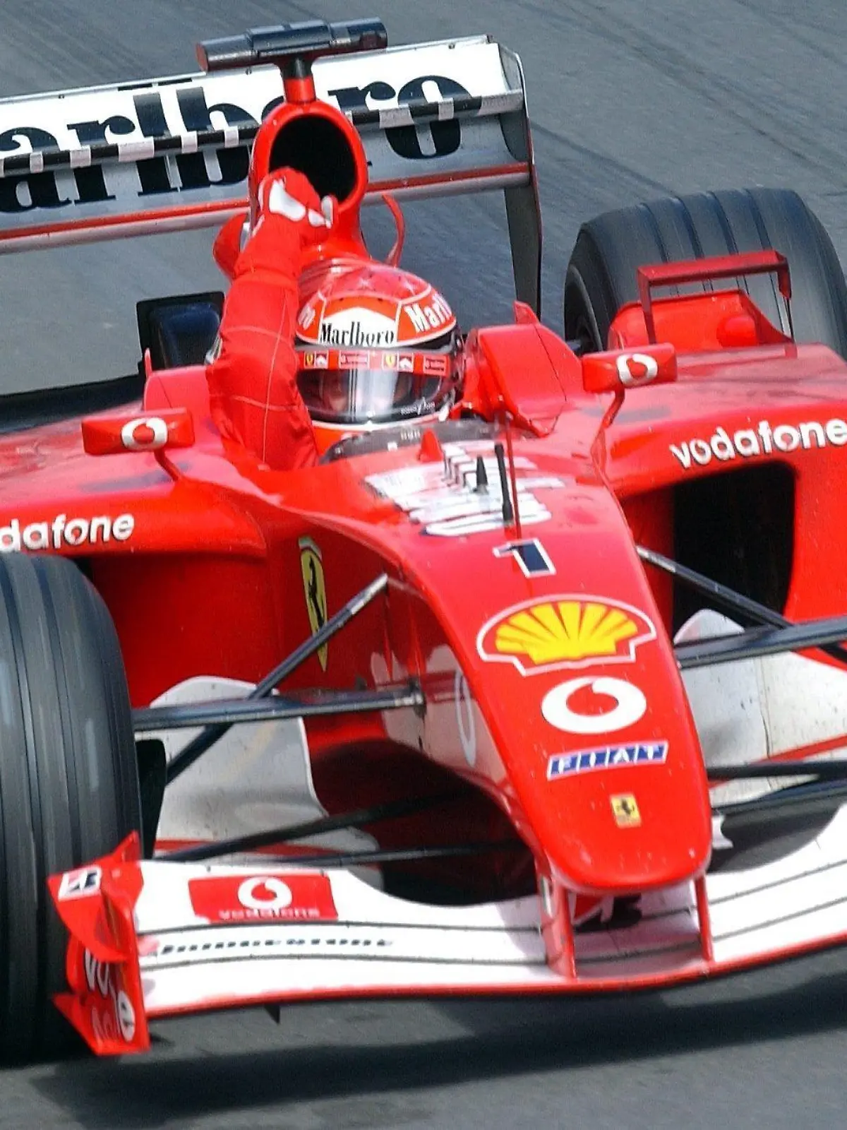 Der deutsche Formel-1-Pilot Michael Schumacher (Ferrari) reckt am 03.03.2002 bei der Zieldurchfahrt auf der Rennstrecke im Albert-Park von Melbourne beim Großen Preis von Australien die Faust aus dem Cockpit. Der viermalige Weltmeister aus Kerpen gewinnt das dramatische Auftaktrennen zur Formel-1-Weltmeisterschaft 2002 und feiert damit einen Saisonstart nach Maß.