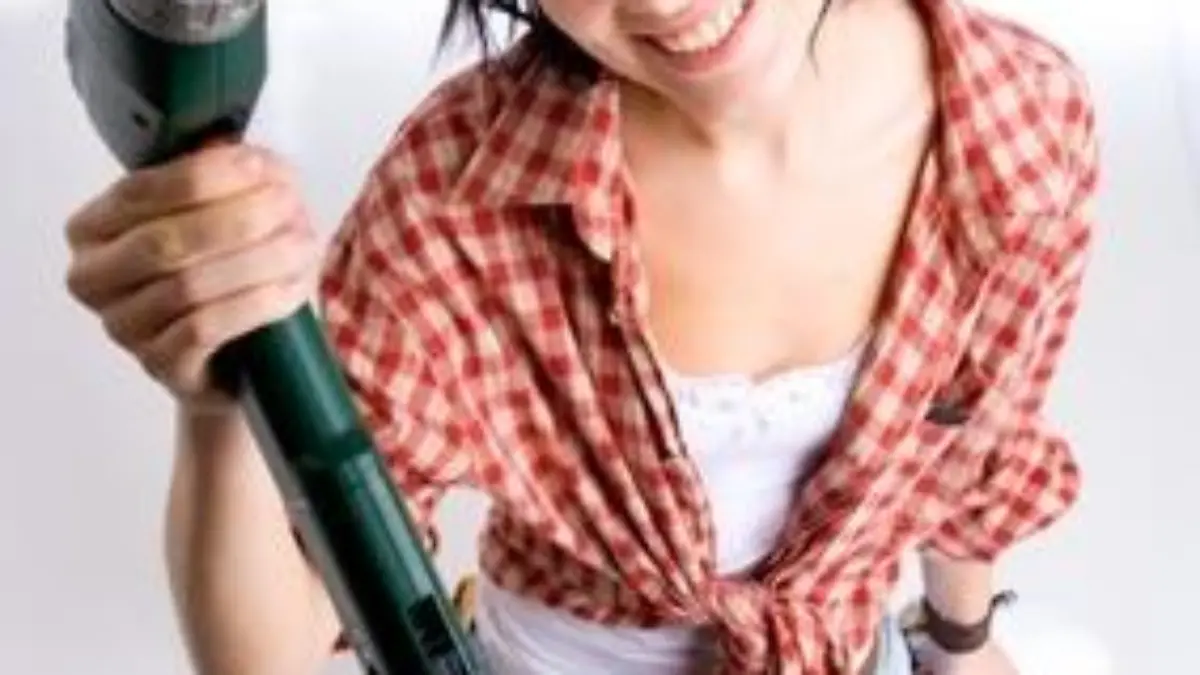 Weitwinkelfoto einer jungen Heimwerkerin mit Bohrmaschine
