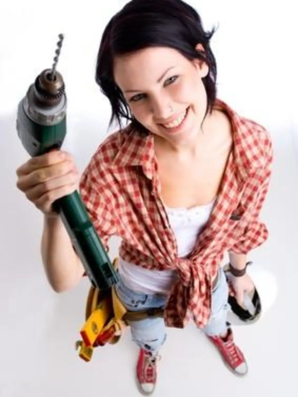Weitwinkelfoto einer jungen Heimwerkerin mit Bohrmaschine