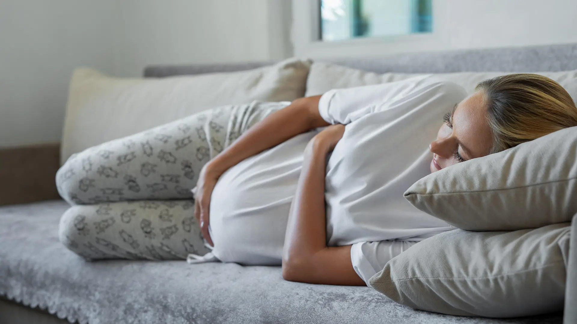 Pregnant woman lying on sofa