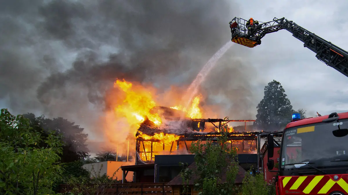 dpatopbilder - 09.08.2023, Frankreich, Wintzenheim: RECROP - Feuerwehrleute löschen einen Brand in einer Ferienunterkunft. Elf Menschen wurden nach dem Feuer vermisst. Frankreichs Innenminister Gerald Darmanin zufolge beherbergt die Stätte behinderte Menschen. Die Präfektur schrieb, dass sich eine Erwachsenengruppe aus Nancy für die Ferien in der Unterkunft aufhielt. Foto: Patrick Kerber/dpa +++ dpa-Bildfunk +++