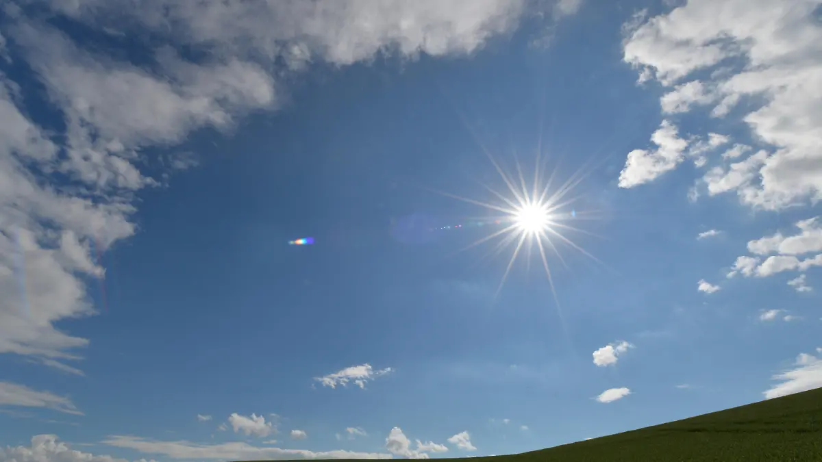 Die Sonne scheint am 21.06.2013 bei Teistungen (Thüringen) über einem Kornfeld. Foto: Marc Tirl/dpa +++(c) dpa - Bildfunk+++