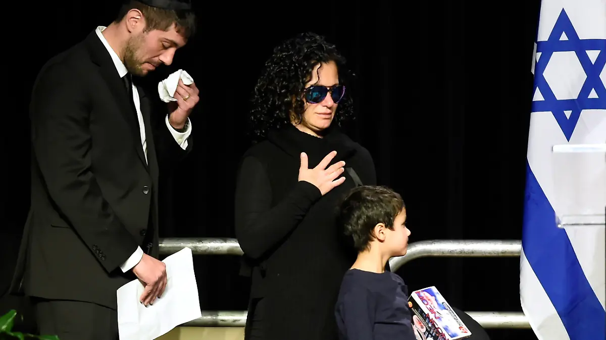 FILE - In this Dec. 21, 2017 file photo, Jonathon Sherman wipes his tears as he and his sister Lauren walk to the stage during a memorial service in Mississauga, Ontario, for their parents Barry and Honey Sherman, who were found dead inside their mansion. The day after the bodies were discovered, prominent media outlets quoted unnamed police sources as saying it appeared to be a murder-suicide. The family blasted the Toronto police as “irresponsible” for the early reports of a murder-suicide, and hired their own investigator and pathologist to conduct second autopsies on Barry and Honey Sherman. (Nathan Denette/The Canadian Press via AP File)
