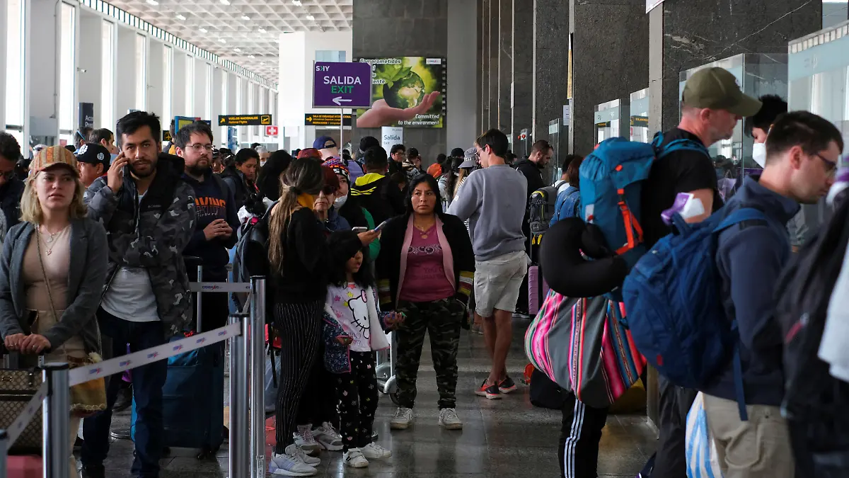 Travelers wait in line in front of airline counters for news about flights at the airport, after it was closed due to protests sparked by the ousting of former President Pedro Castillo, in Cuzco, Peru December 16, 2022. REUTERS/Paul Gambin NO RESALES. NO ARCHIVES.