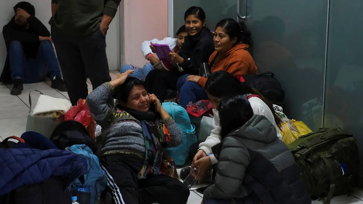 People rest on the floor as they wait for news about flights at the airport after it was closed due to protests sparked by the ousting of former President Pedro Castillo, in Cuzco, Peru December 16, 2022. REUTERS/Paul Gambin NO RESALES. NO ARCHIVES.