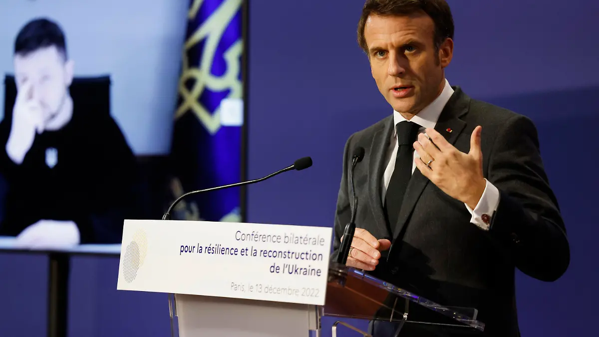 13.12.2022, Frankreich, Paris: Emmanuel Macron (r), Präsident von Frankreich hält eine Rede, während Wolodymyr Selenskyj, Präsident der Ukraine, über eine Videoverbindung an der französisch-ukrainischen Konferenz für Resilienz und Wiederaufbau teilnimmt. Foto: Ludovic Marin/POOL AFP/AP/dpa +++ dpa-Bildfunk +++