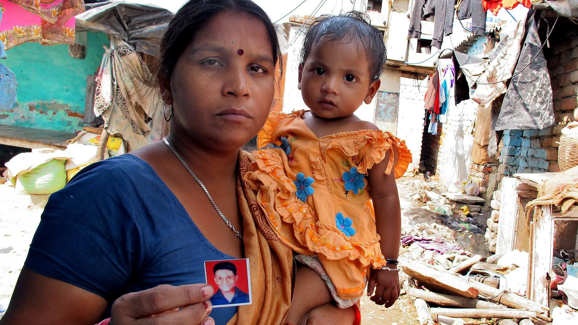 Leelavati hält am 15.04.2013 im Stadtteil Jehangirpuri von Neu Delhi, Indien, ein Bild ihres Sohnes Sonu in der Hand. Der Junge verschwand 2009 spurlos. Auf dem Land verschwinden meist die Kinder aus den einfachsten Hütten, in den Städten sind es die Söhne und Töchter der armen Zuwanderer. Foto: Sunrita Sen/dpa (zu dpa "Haussklaven, Sexarbeiter, Bettler - Indiens vermisste Kinder" vom 24.05.2013)Foto: Sunrita Sen/dpa (zu dpa "Haussklaven, Sexarbeiter, Bettler - Indiens vermisste Kinder" vom 24.05.2013) +++(c) dpa - Bildfunk+++