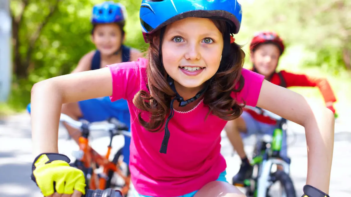 Portrait of a little girl riding her bike ahead of her friends