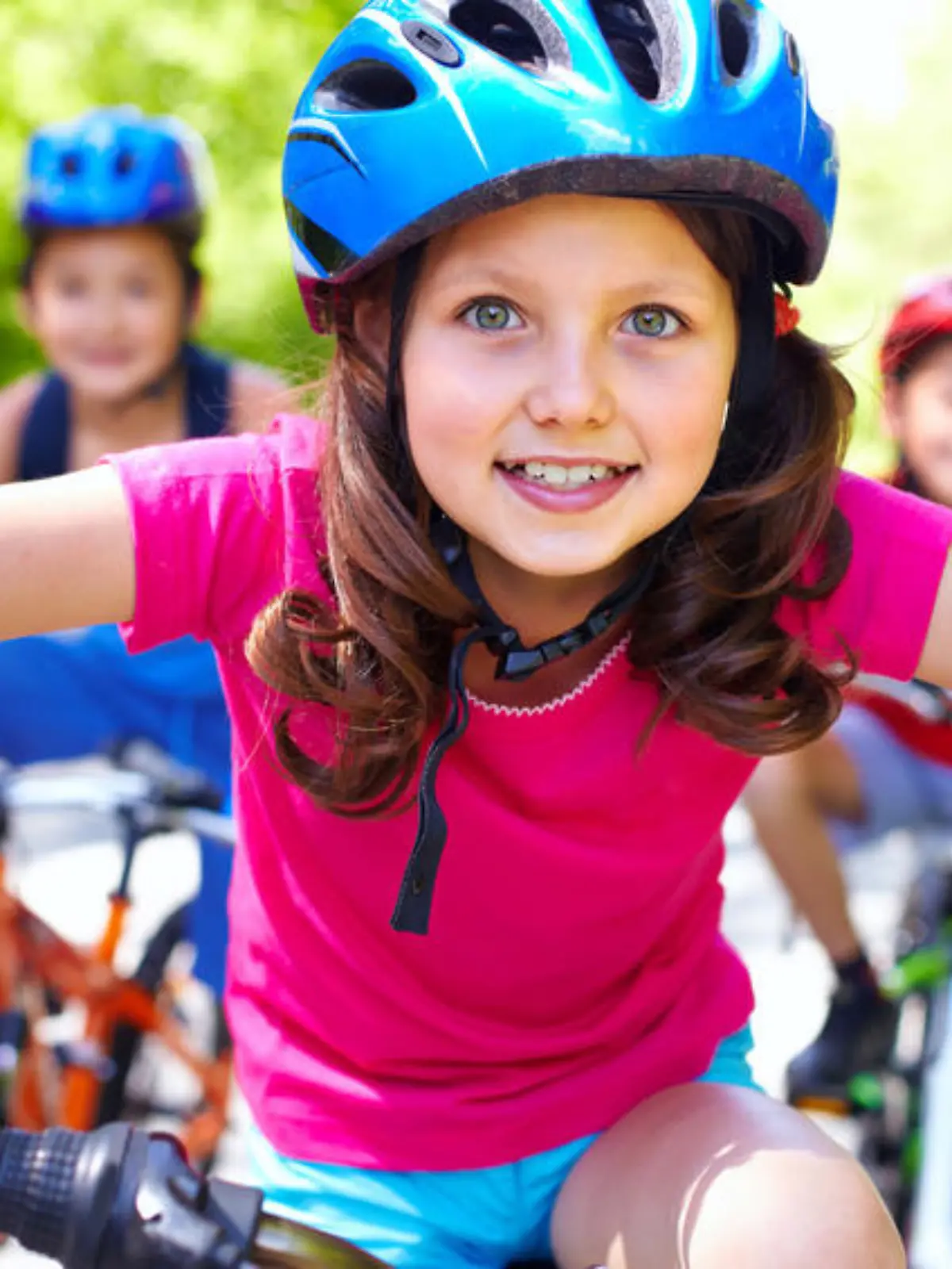 Portrait of a little girl riding her bike ahead of her friends
