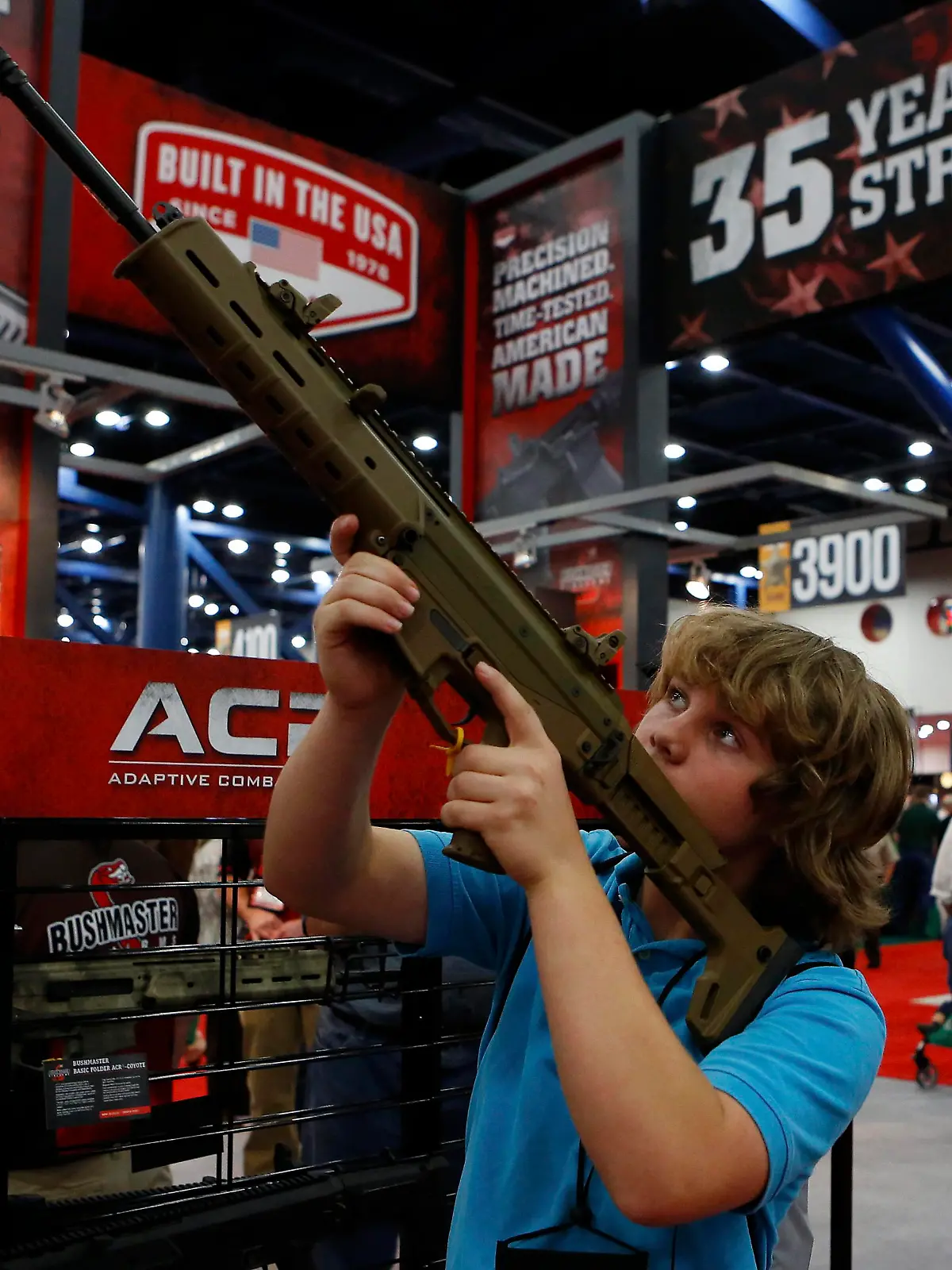epa03686671 James Beaver, 13, looks through the scope of a Bushmaster gun during the 2013 National Rifle Association (NRA) Annual Meetings & Exhibits at the George R. Brown Convention Center in Houston, Texas, USA, 03 May 2013. The National Rifle Association is a nonprofit organization that promotes firearm ownership, as well as police training, firearm safety, marksmanship, hunting and self-defense training in the United States. The association has over four million members. EPA/AARON M. SPRECHER