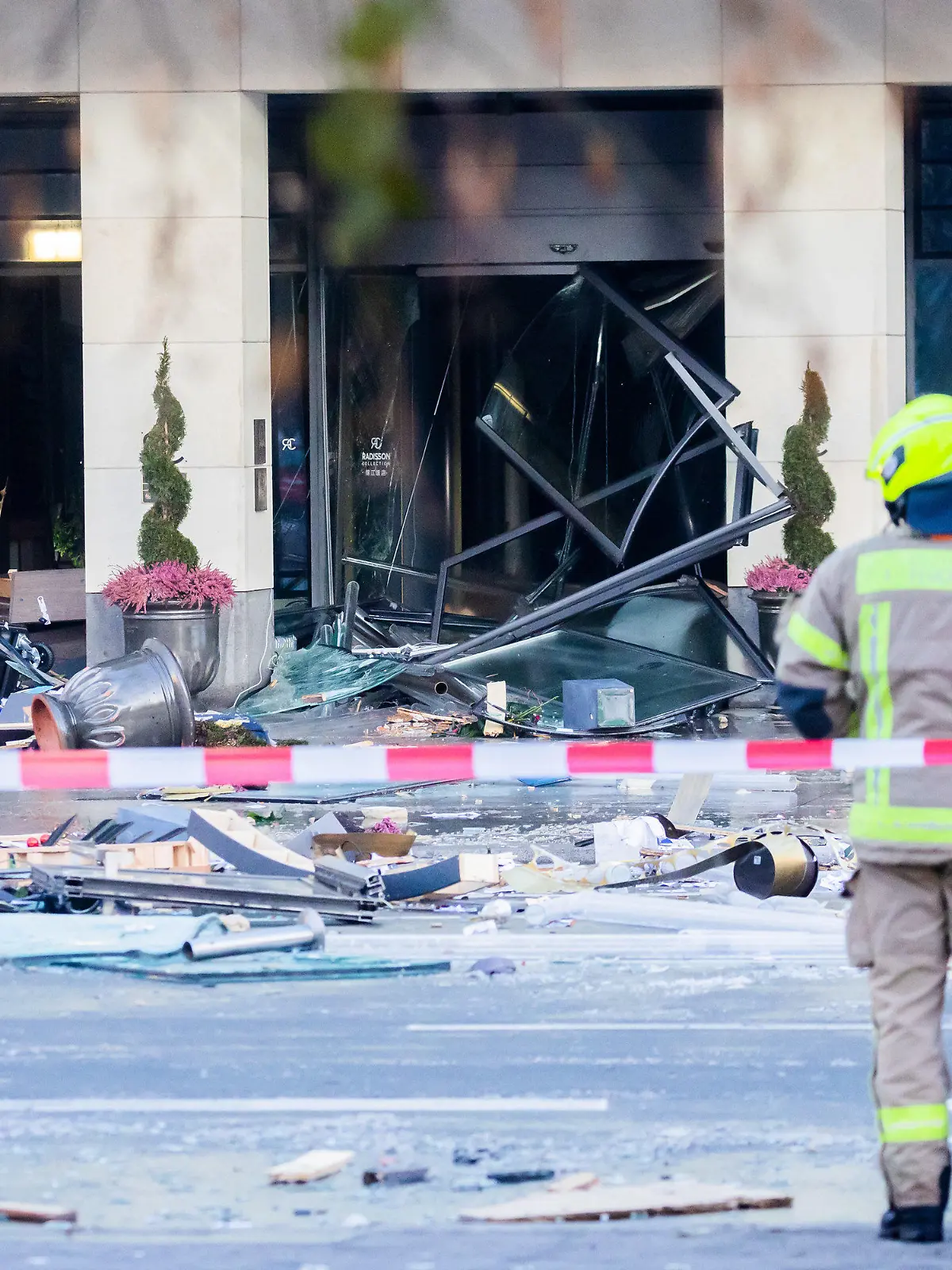 16.12.2022, Berlin: Trümmer liegen auf der Karl-Liebknecht-Straße vor einem Hotel. In dem Hotel war ein riesiges Aquarium leck geschlagen. Wasser strömte bis auf die Straße. Foto: Christoph Soeder/dpa +++ dpa-Bildfunk +++