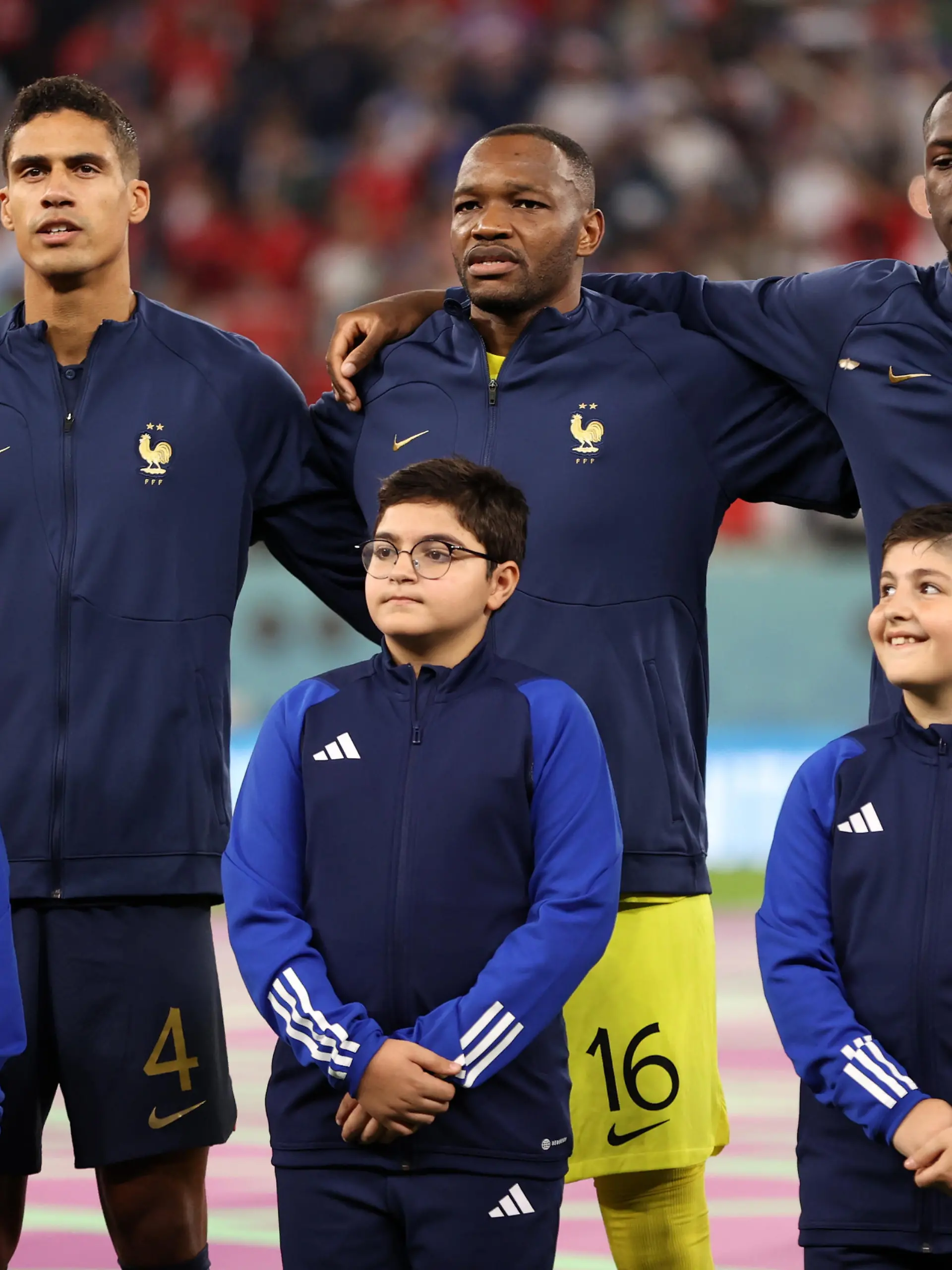AL RAYYAN, QATAR - NOVEMBER 30: Raphael Varane, Steve Mandanda and Ibrahima Konate of France sing their national anthem prior to the FIFA World Cup Qatar 2022 Group D match between Tunisia and France at Education City Stadium on November 30, 2022 in Al Rayyan, Qatar. (Photo by Ryan Pierse/Getty Images)