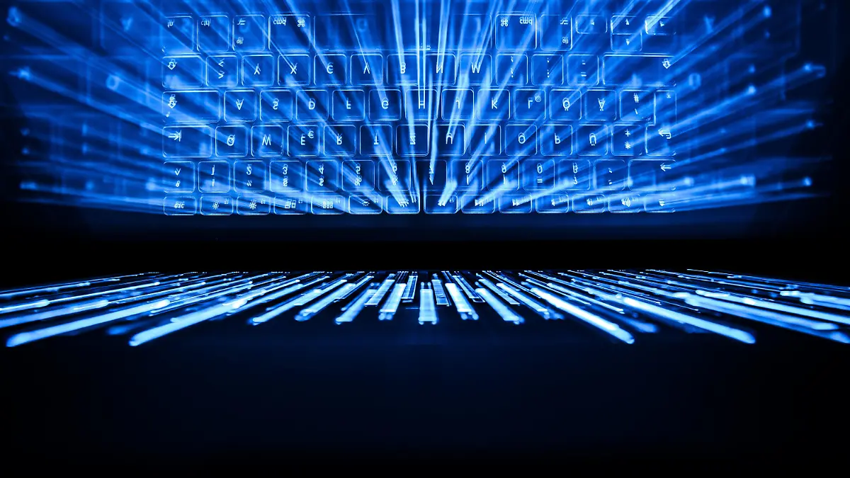 ILLUSTRATION - 26.04.2019, Hessen, Rüsselsheim: Die beleuchtete Tastatur eines Laptops spiegelt sich im Bildschirm. Ermittlern ist ein Schlag gegen Internetforen im Darknet mit Darstellungen des sexuellen Missbrauchs von Kindern geglückt. Dies bestätigte am Freitag ein Sprecher der Zentralstelle zur Bekämpfung der Internetkriminalität in Hessen. (zu dpa: "Ermittlern gelingt Schlag gegen Darknet-Foren mit Kindesmissbrauch") Foto: Silas Stein/dpa +++ dpa-Bildfunk +++