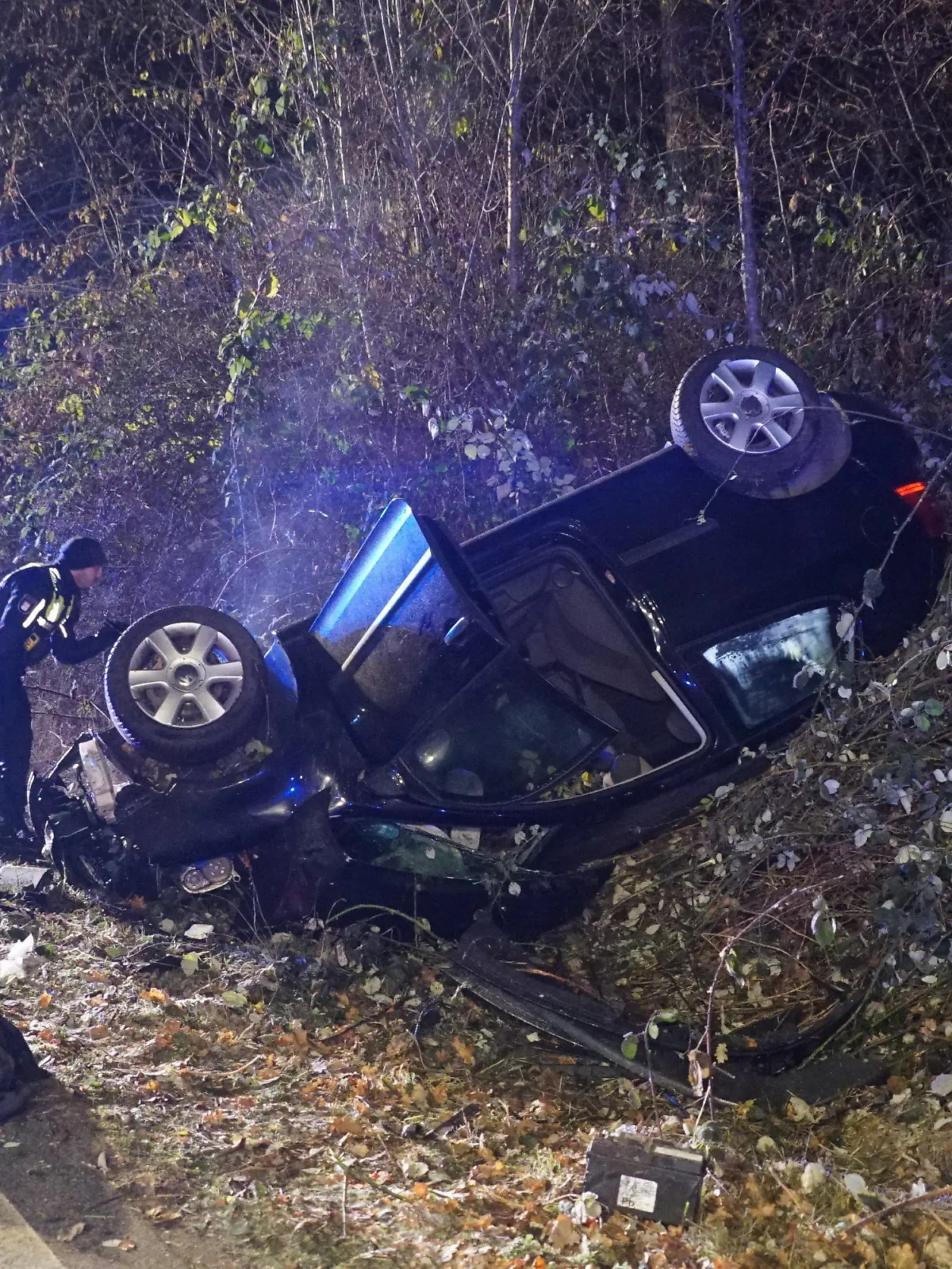 14.12.2022, Hamburg: Ein Unfallwagen liegt auf dem Dach in einer Böschung. Bei einem Verkehrsunfall auf einer Kreuzung in Hamburg-Öjendorf hat sich ein Auto überschlagen. Zwei Autofahrer seien bei dem Zusammenstoß am Mittwochabend verletzt worden, sagte ein Polizeisprecher. Einer der Männer habe zuvor die Vorfahrtsregel an der Kreuzung missachtet, der andere sei zu schnell gefahren und vermutlich alkoholisiert gewesen. Die beiden Verletzen wurden ins Krankenhaus gebracht. Foto: Citynewstv/dpa +++ dpa-Bildfunk +++