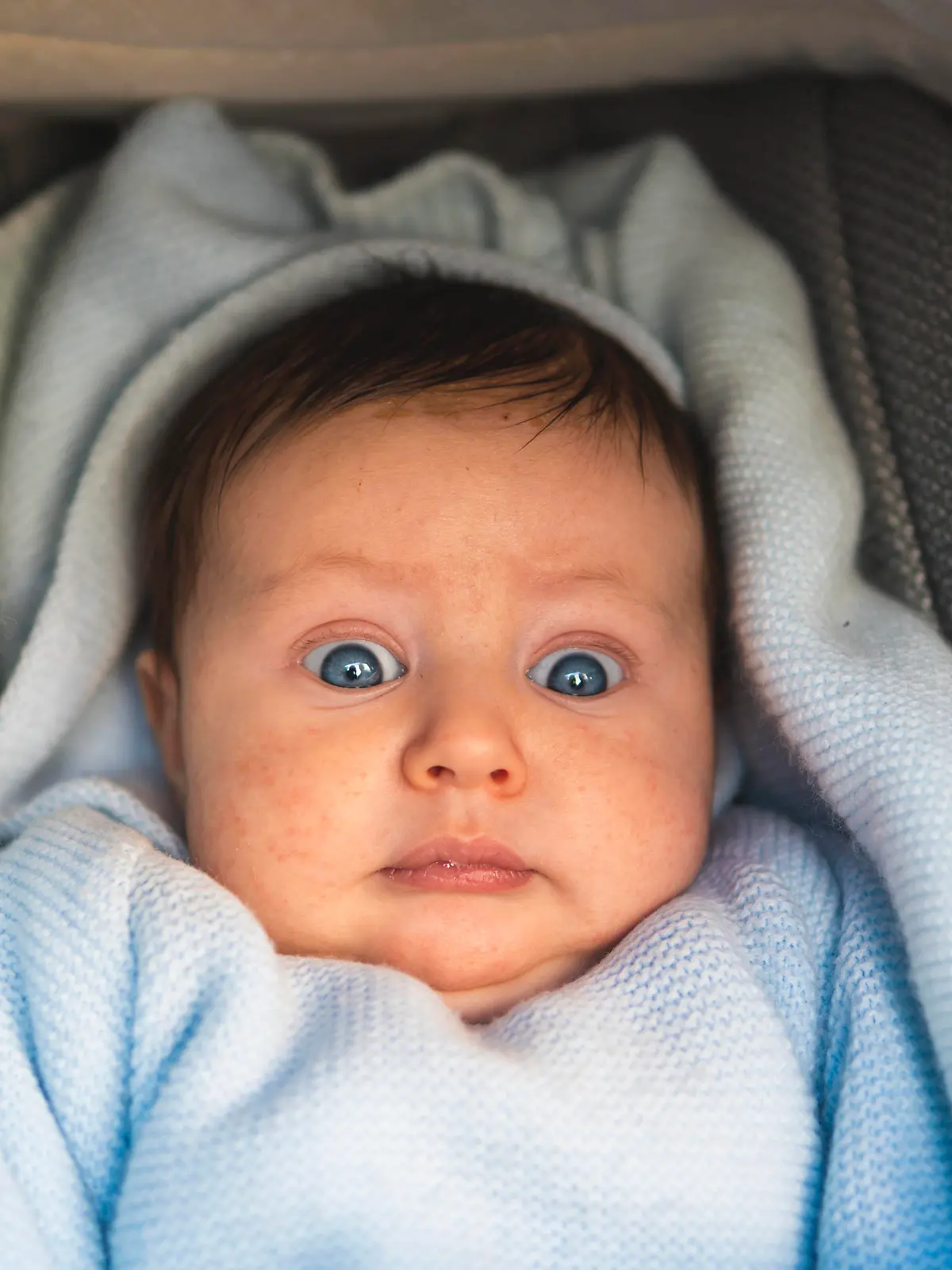 Surprised baby boy lying in pram model released Symbolfoto JAQF00664 