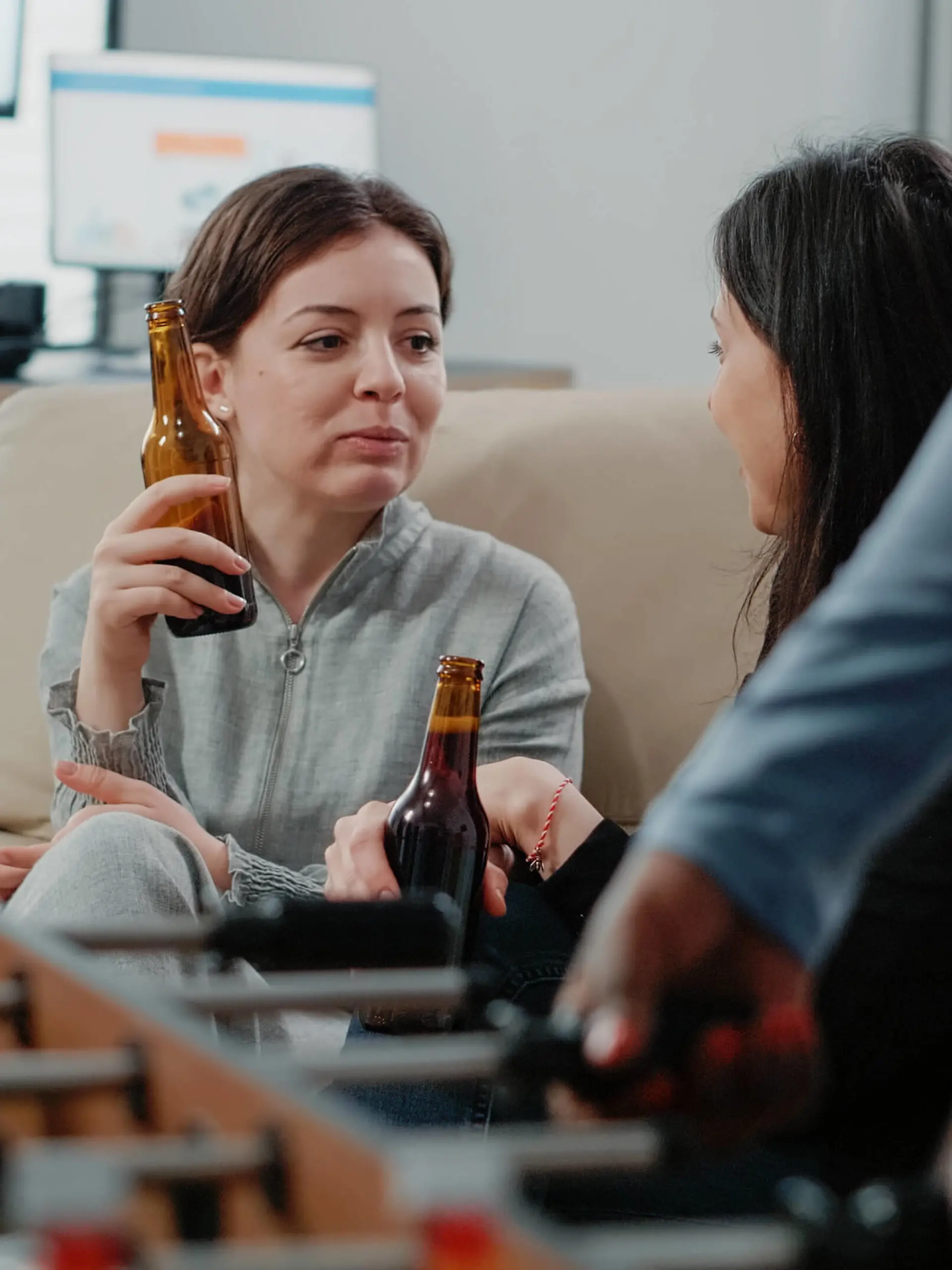 IMAGO Creative: Business - Work-Life Balance  Close up of women with bottles of beer and snacks talking Close up of women with bottles of beer and snacks talking at office after work. Colleagues enjoying free time with alcoholic beverage to do fun activity with entertainment after hours Copyright: xx 43945936