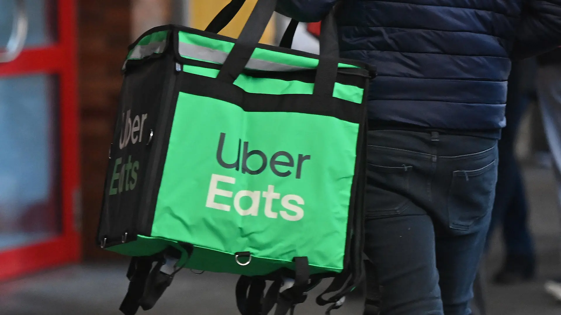 UberEats Essenslieferung,Ein Mann traegt eine Isoliertasche mit warmen Mahlzeiten. Ein