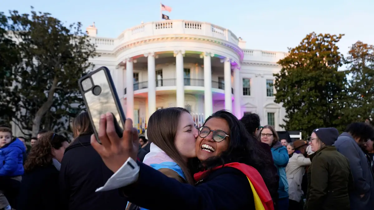 Aparna Shrivastava, right, takes a photo as her partner Shelby Teeter gives her a kiss, after President Joe Biden signed the Respect for Marriage Act, Tuesday, Dec. 13, 2022, on the South Lawn of the White House in Washington. (AP Photo/Andrew Harnik)