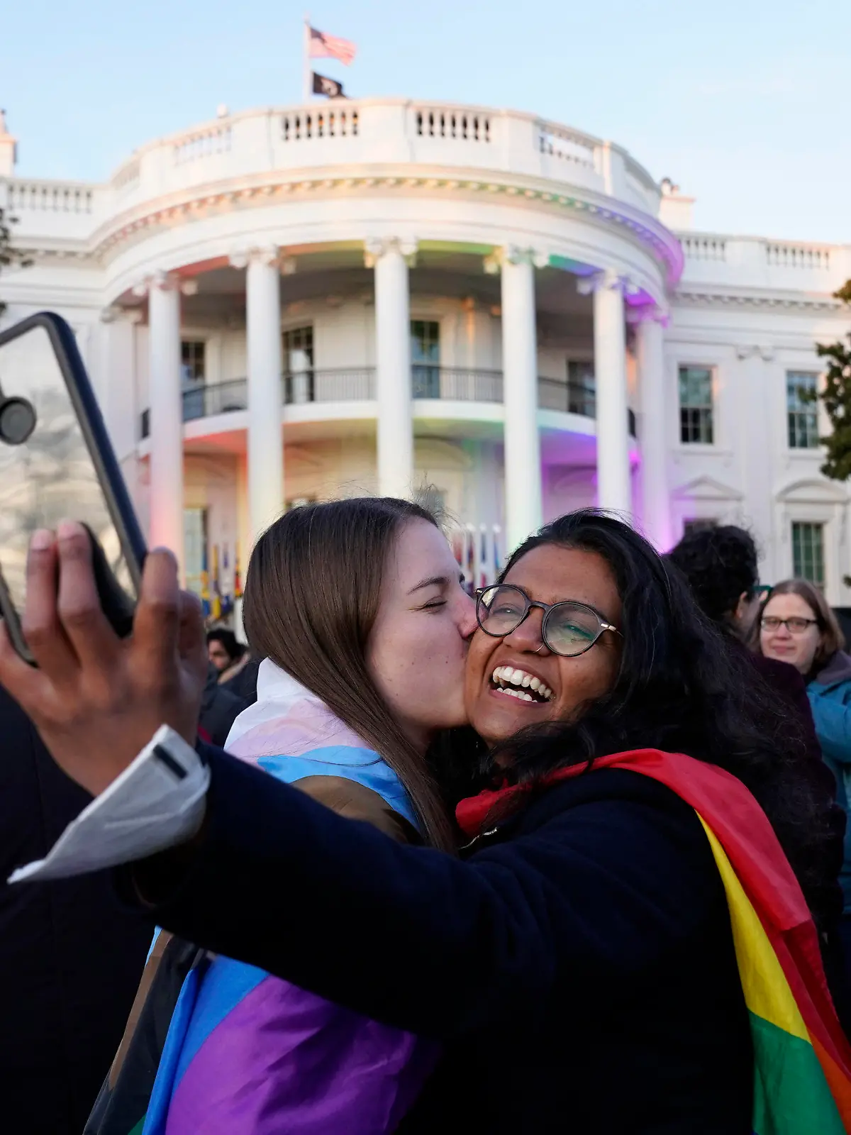 Aparna Shrivastava, right, takes a photo as her partner Shelby Teeter gives her a kiss, after President Joe Biden signed the Respect for Marriage Act, Tuesday, Dec. 13, 2022, on the South Lawn of the White House in Washington. (AP Photo/Andrew Harnik)