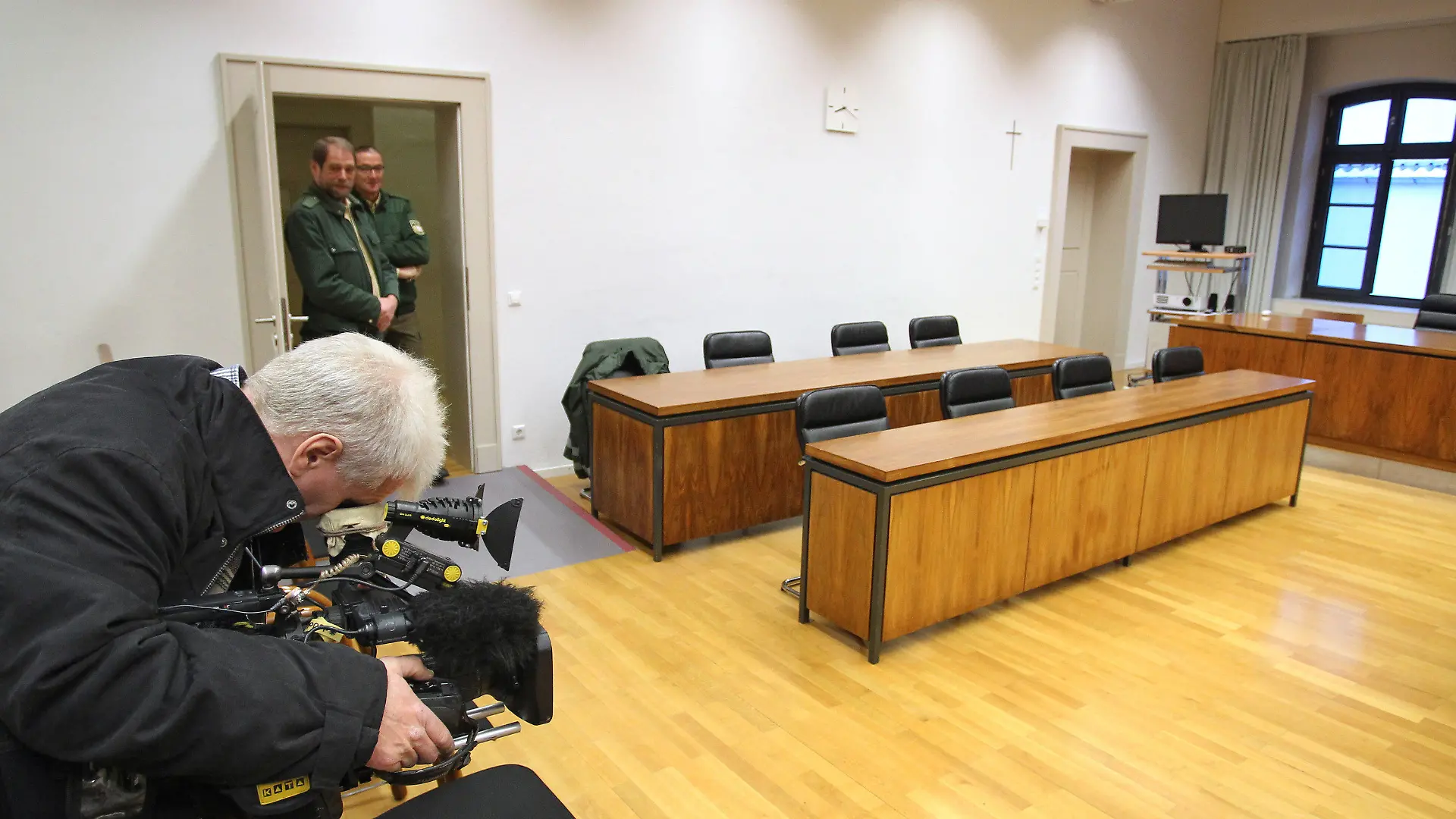 Ein Kameramann steht am 22.01.2013 im Landgericht Memmingen (Bayern) vor einer leeren Anklagebank. Am Vormittag begann dort unter Ausschluss der Öffentlichkeit der Prozess gegen einen 15-jährigen Schüler, der einen Amokalarm an einer Memminger Schule ausgelöst hatte. Foto: Karl-Josef Hildenbrand/dpa +++(c) dpa - Bildfunk+++