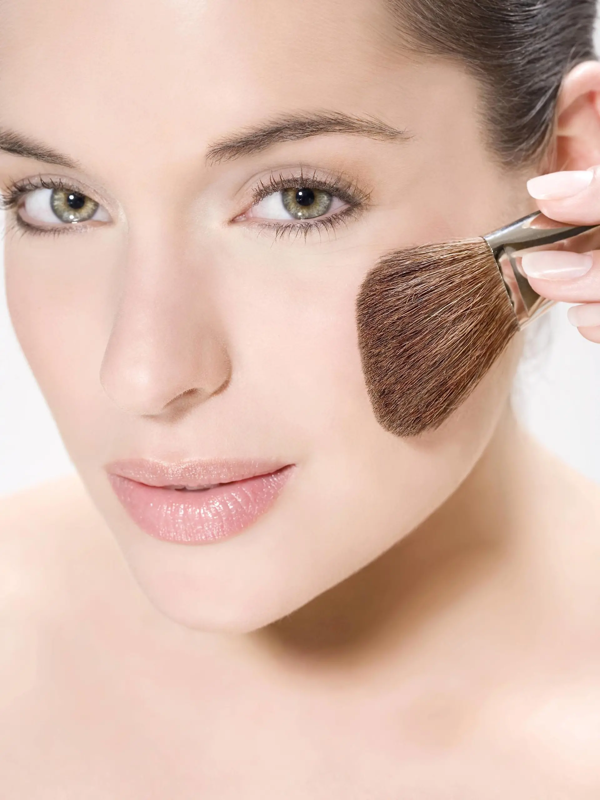Frau traegt mit Pinsel Makeup auf | woman putting on makeup with a brush